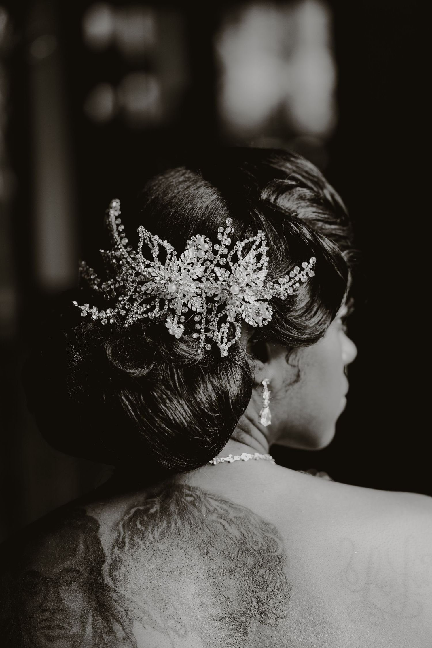 Elegant bridal hairstyle adorned with a delicate crystal headpiece in black and white photograph.