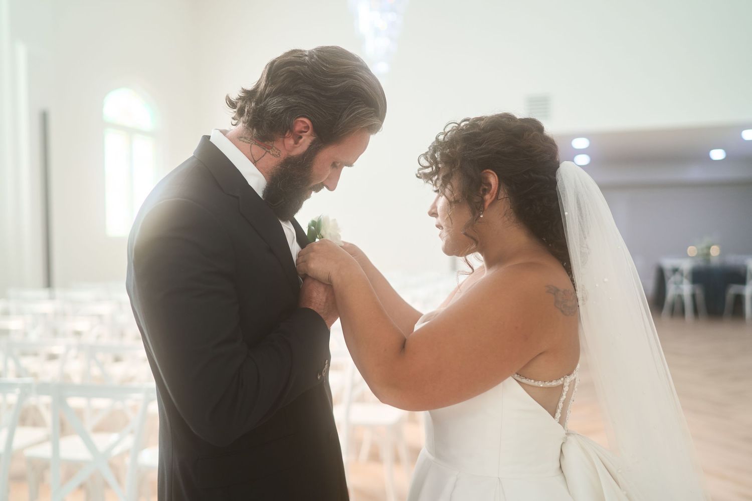 Emotional first look moment between bride and groom in bright indoor wedding venue.