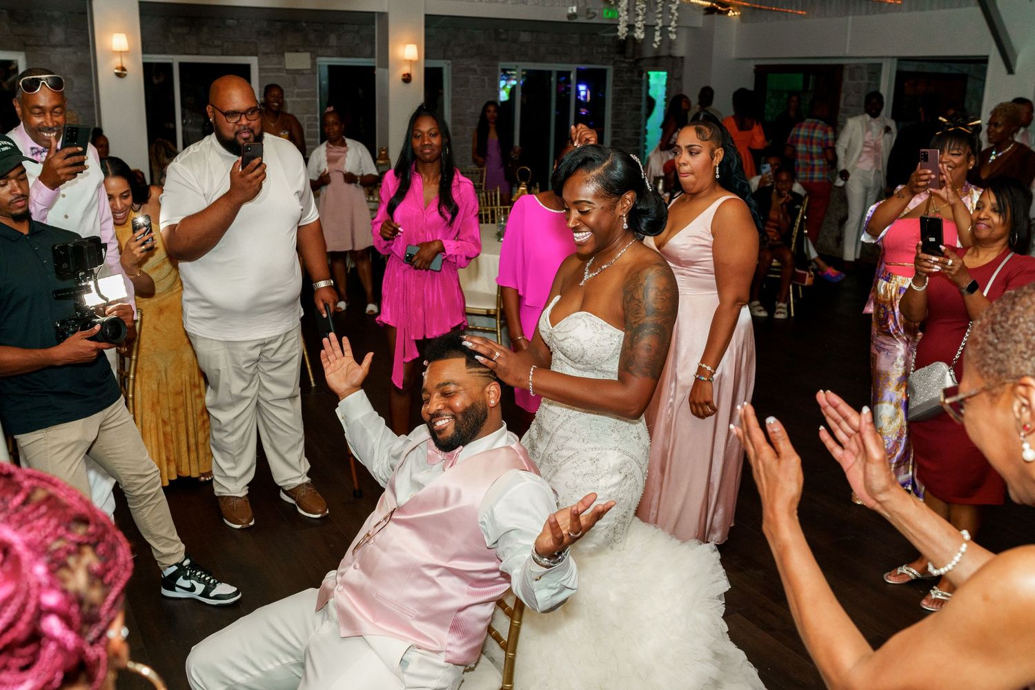 Wedding guests dance and celebrate on the reception dance floor in a joyous moment.