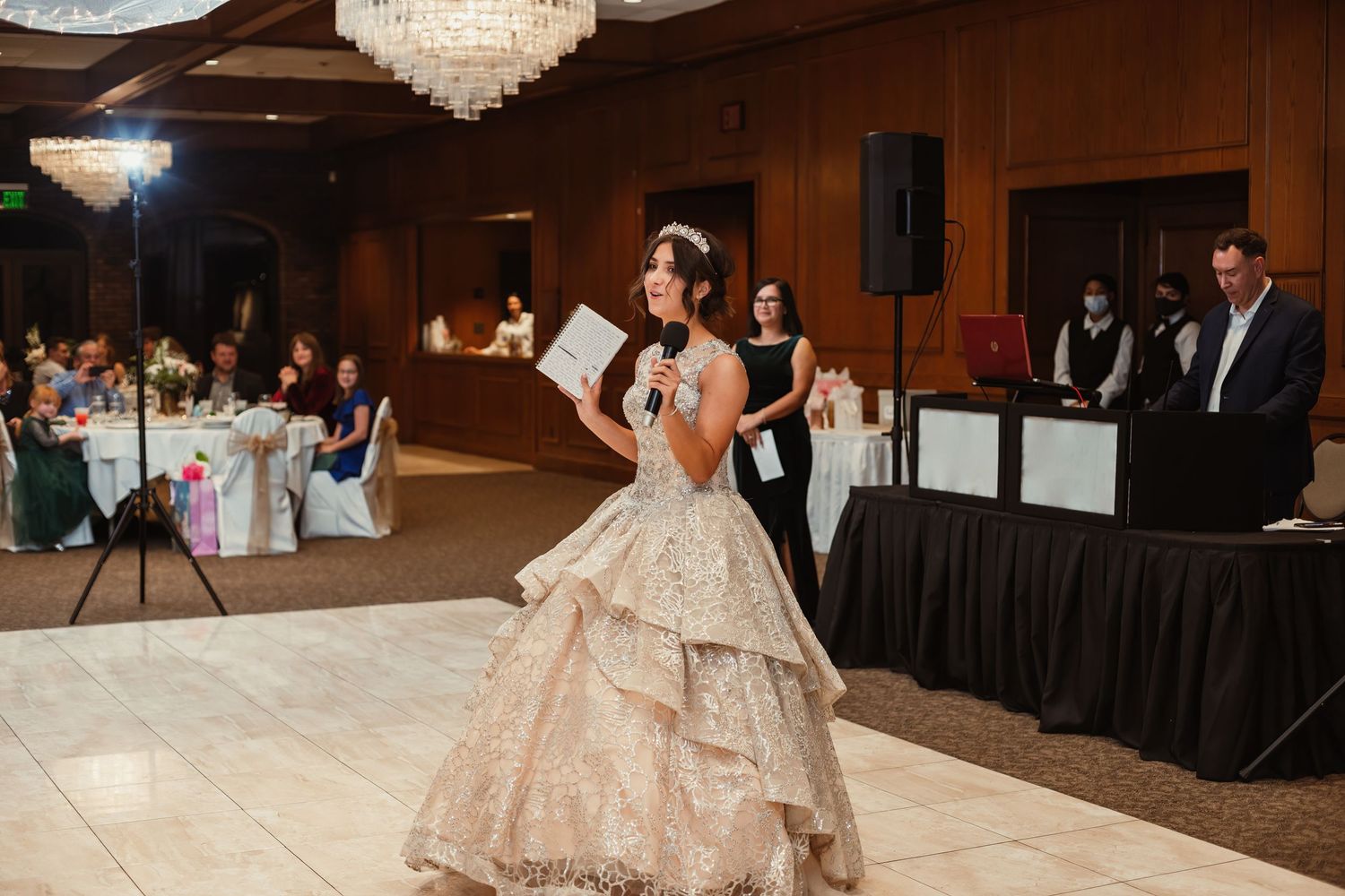 A celebrant in a champagne ballgown performs during a reception.