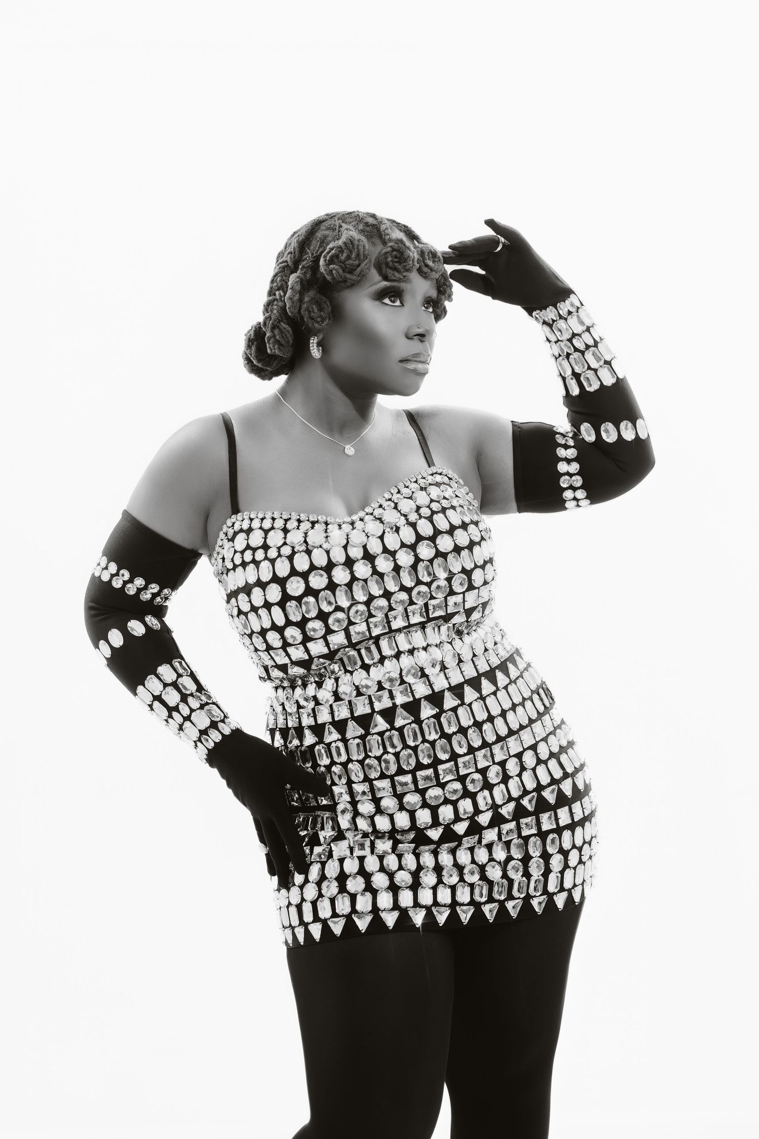 Black and white portrait showing crystal-studded dress and long gloves in classic pose.