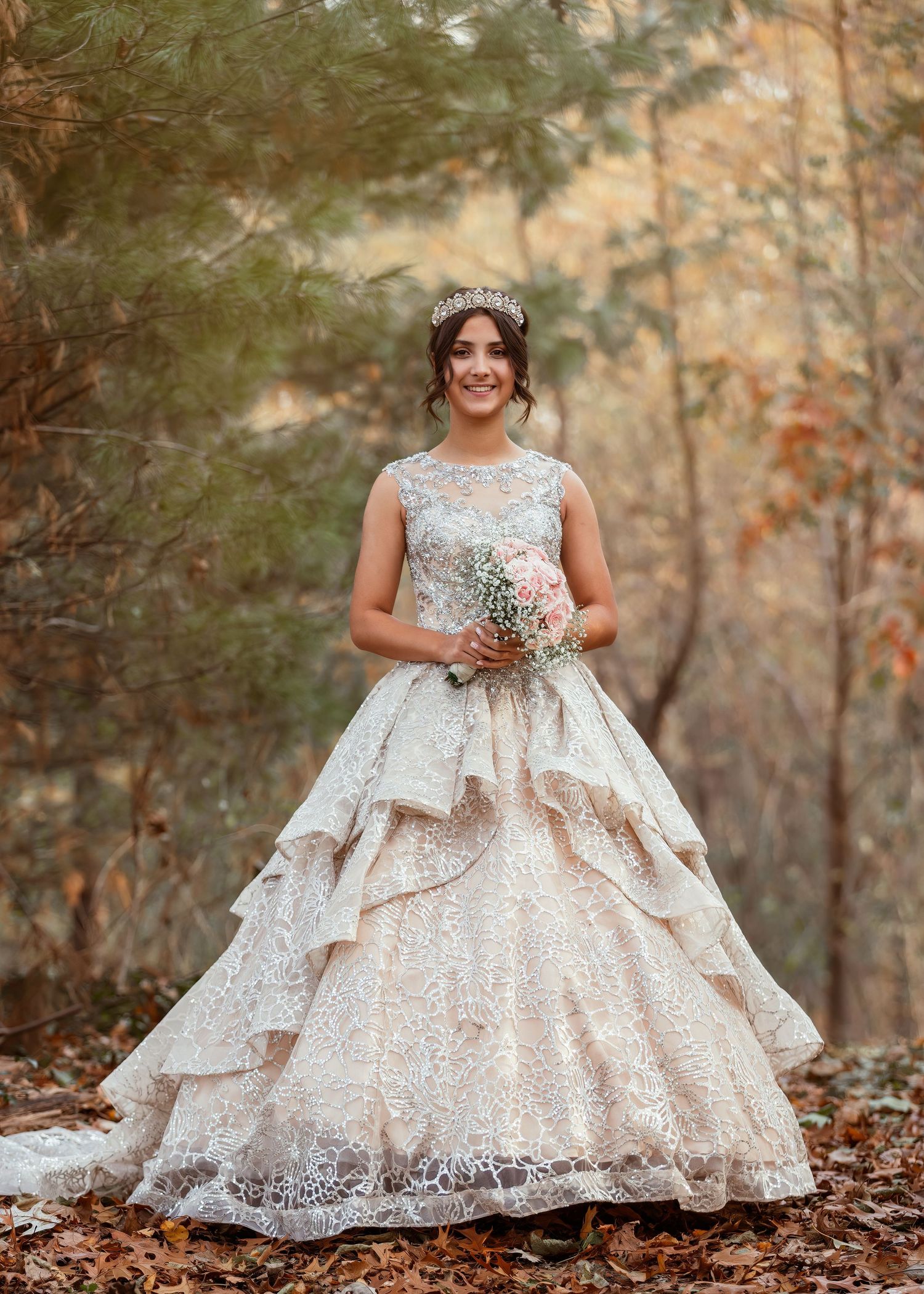 Full-length view of a princess ball gown with layered skirt against fall forest backdrop.