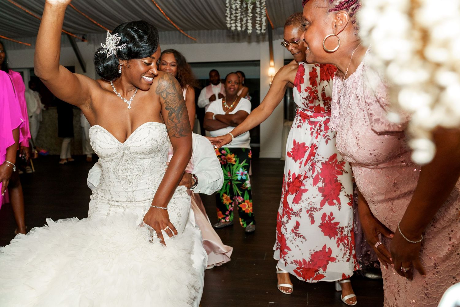 Lively dancing and celebration at a wedding reception with guests in colorful attire.