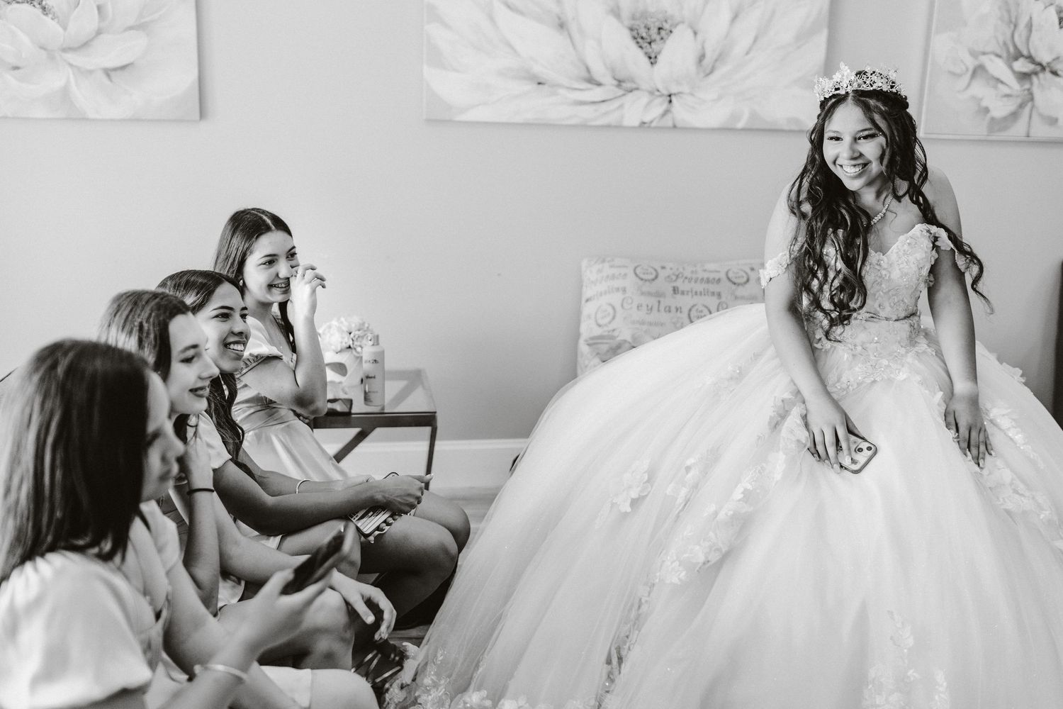 A candid black and white photo captures laughter and joy during wedding preparations.