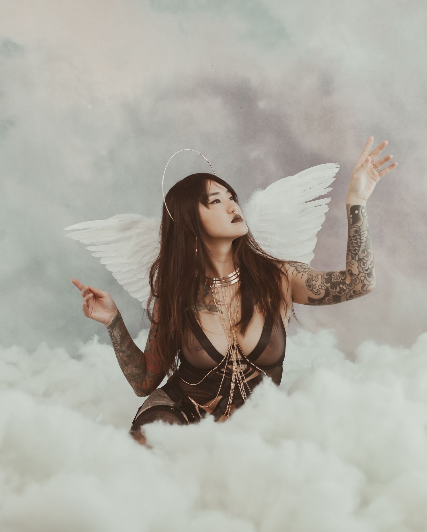 Dark fantasy portrait with angel wings and dramatic poses in cloudy setting.