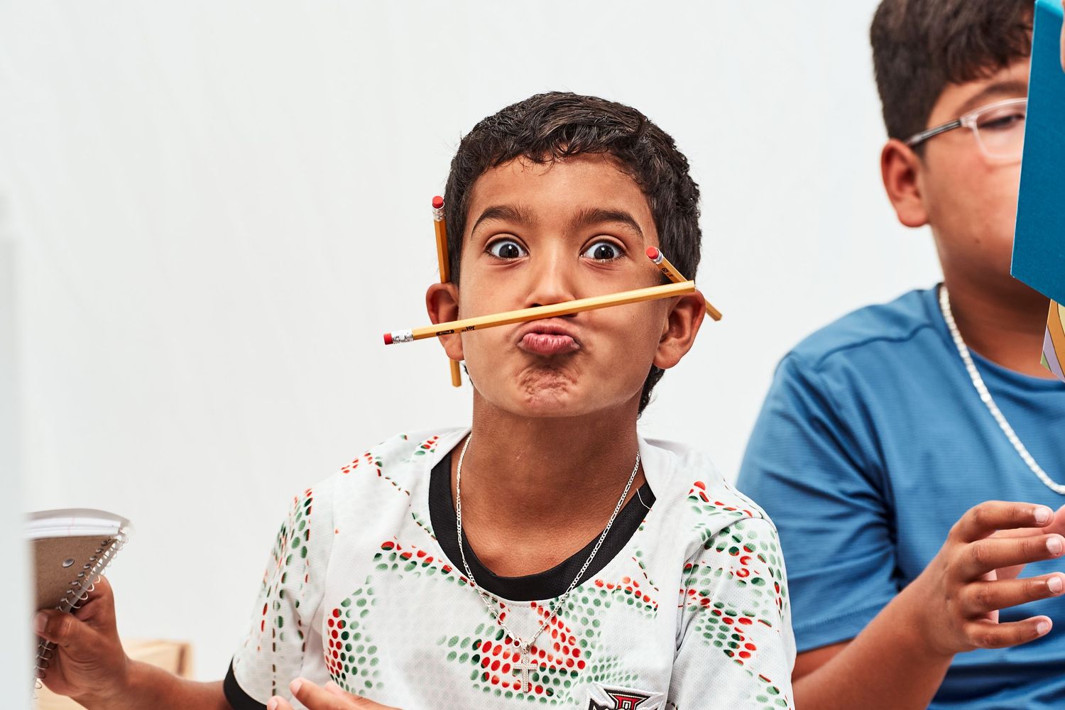 Two children playing with chopsticks and cups during a fun activity or game.