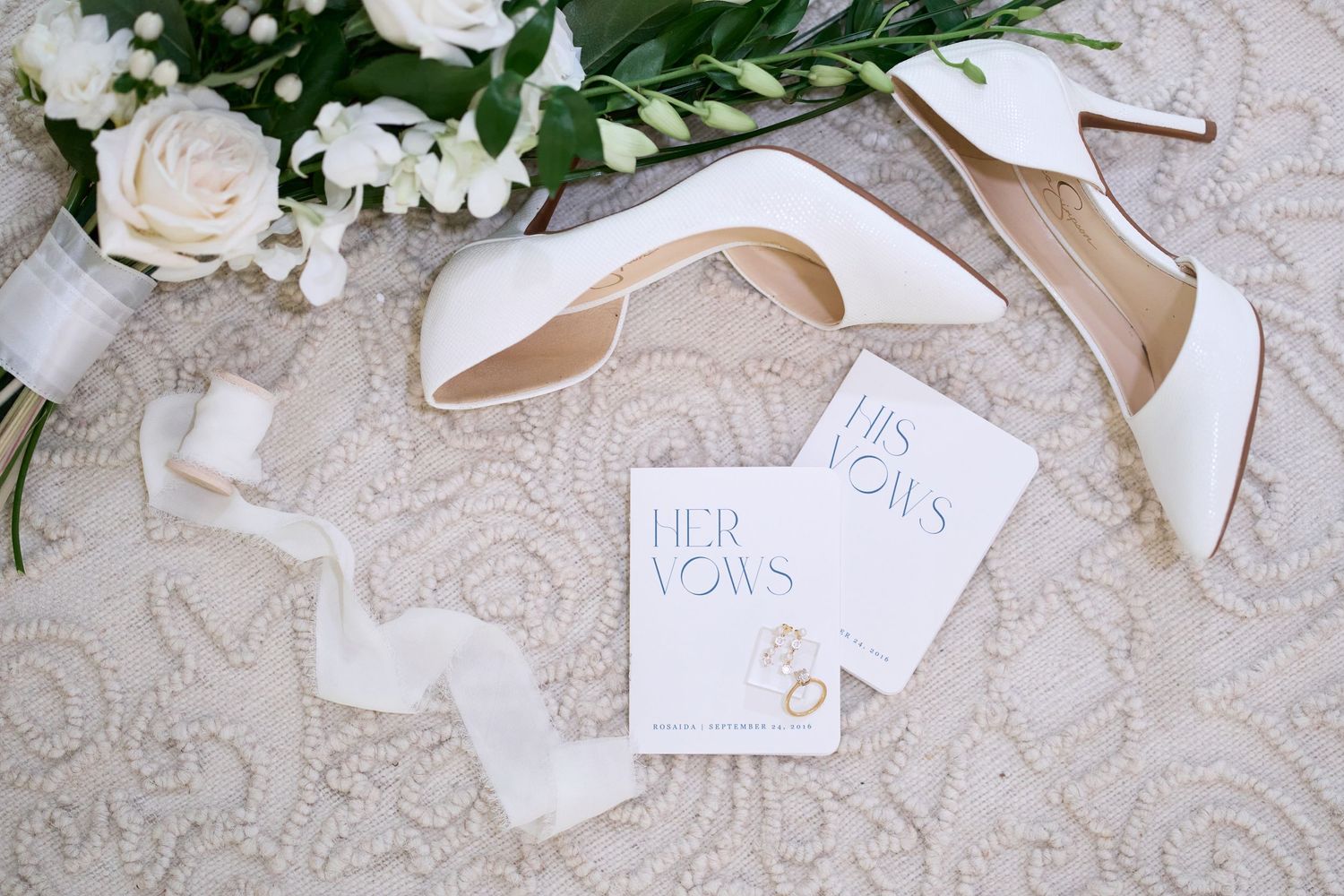 Wedding invitation with fluttering white paper pieces and elegant envelopes on delicate lace background.
