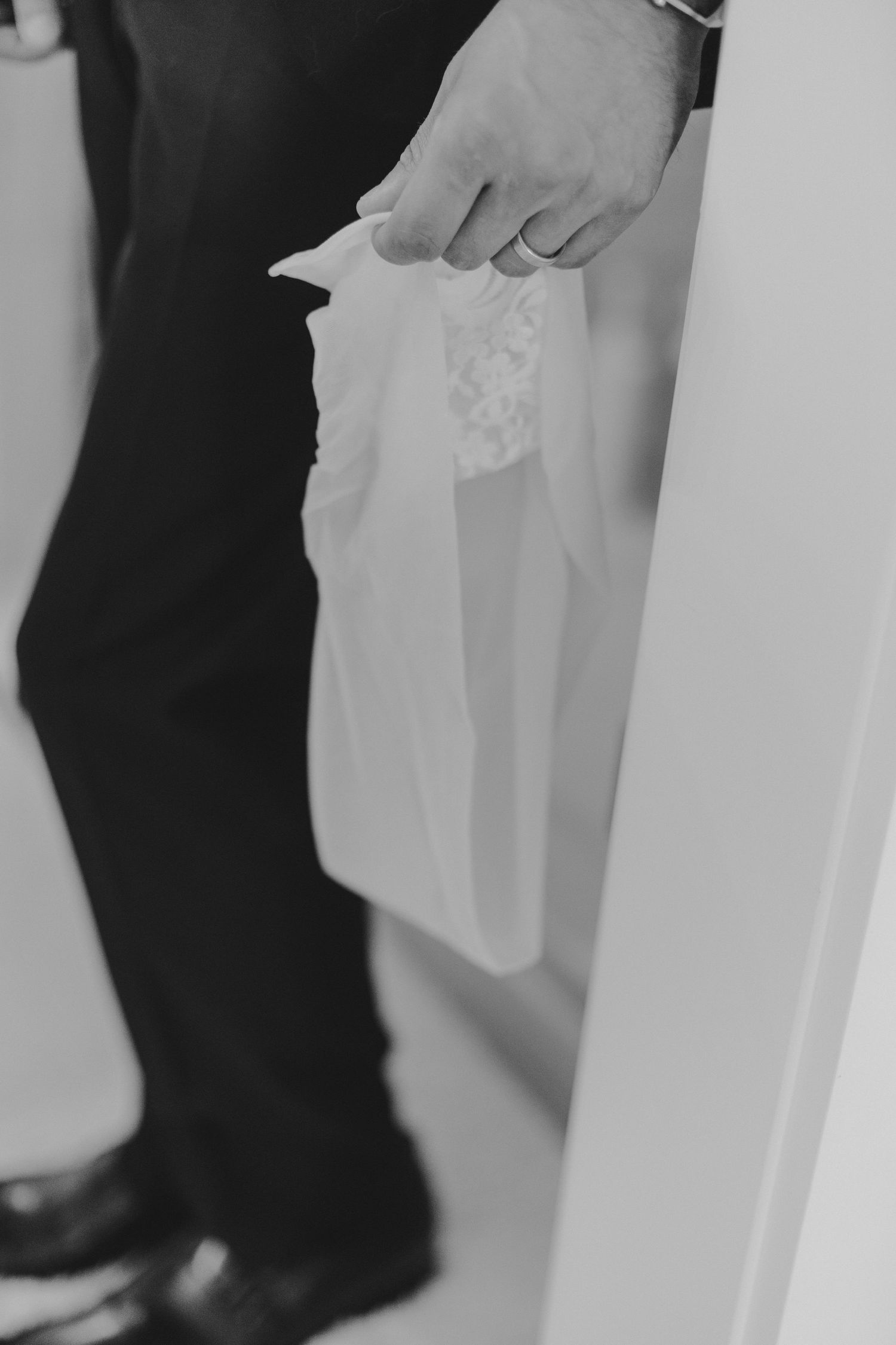 Black and white detail shot of holding wedding dress fabric.