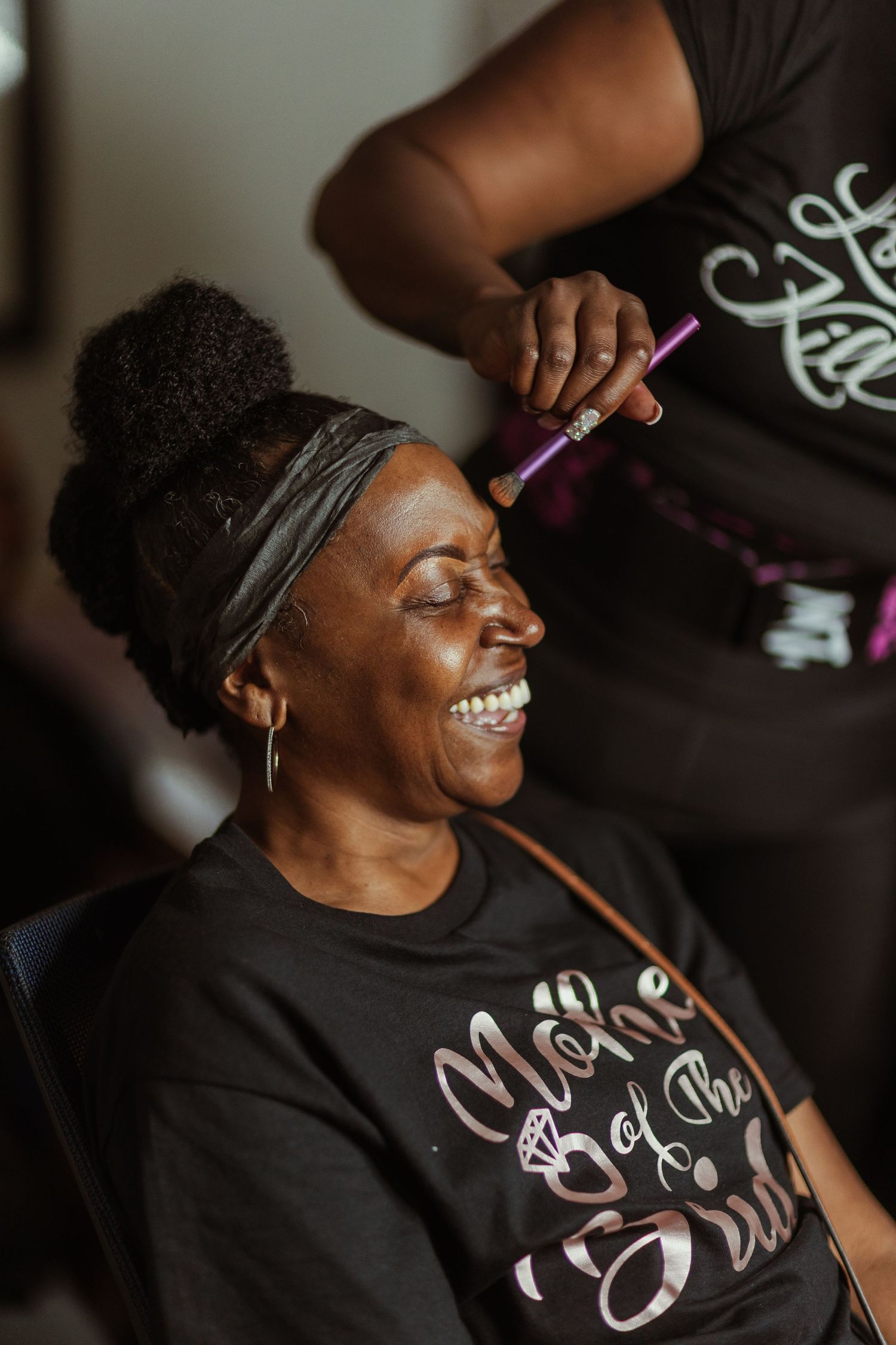 A candid moment of wedding day preparation showing joy and laughter.