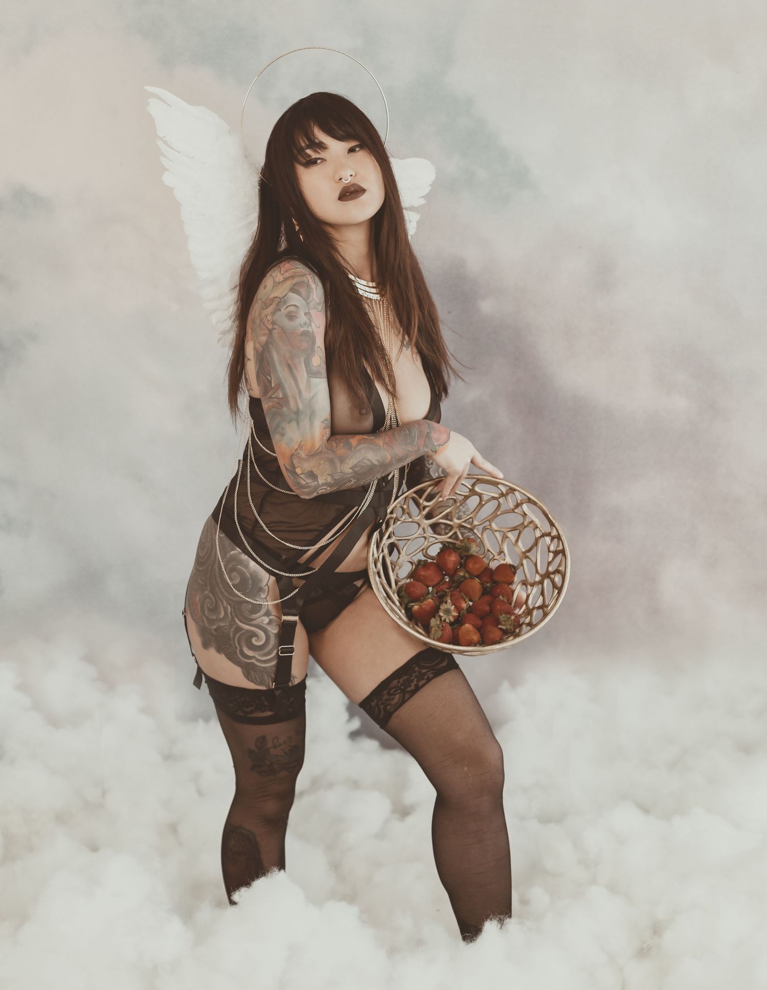 Gothic fantasy portrait with angel wings and stockings in atmospheric cloudy setting.