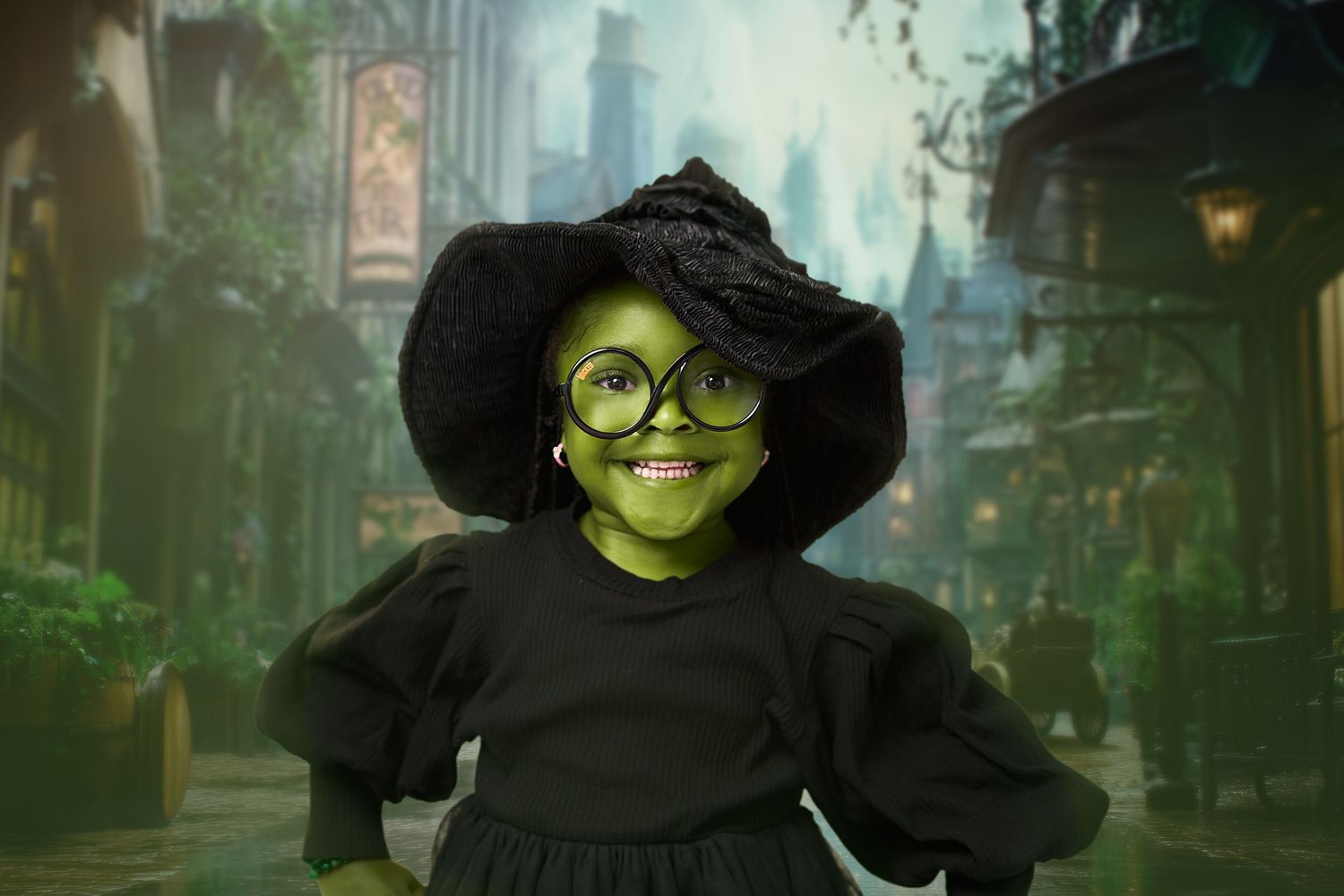 Young witch with round glasses and a black hat stands in a mystical green-lit alley.