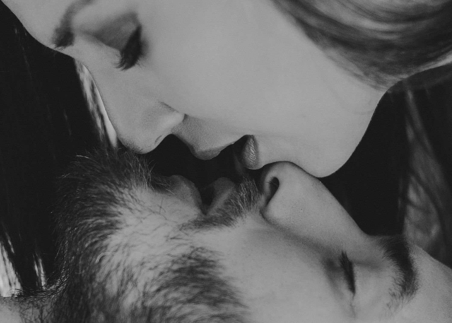 Black and white close-up portrait capturing intimate romantic moment.