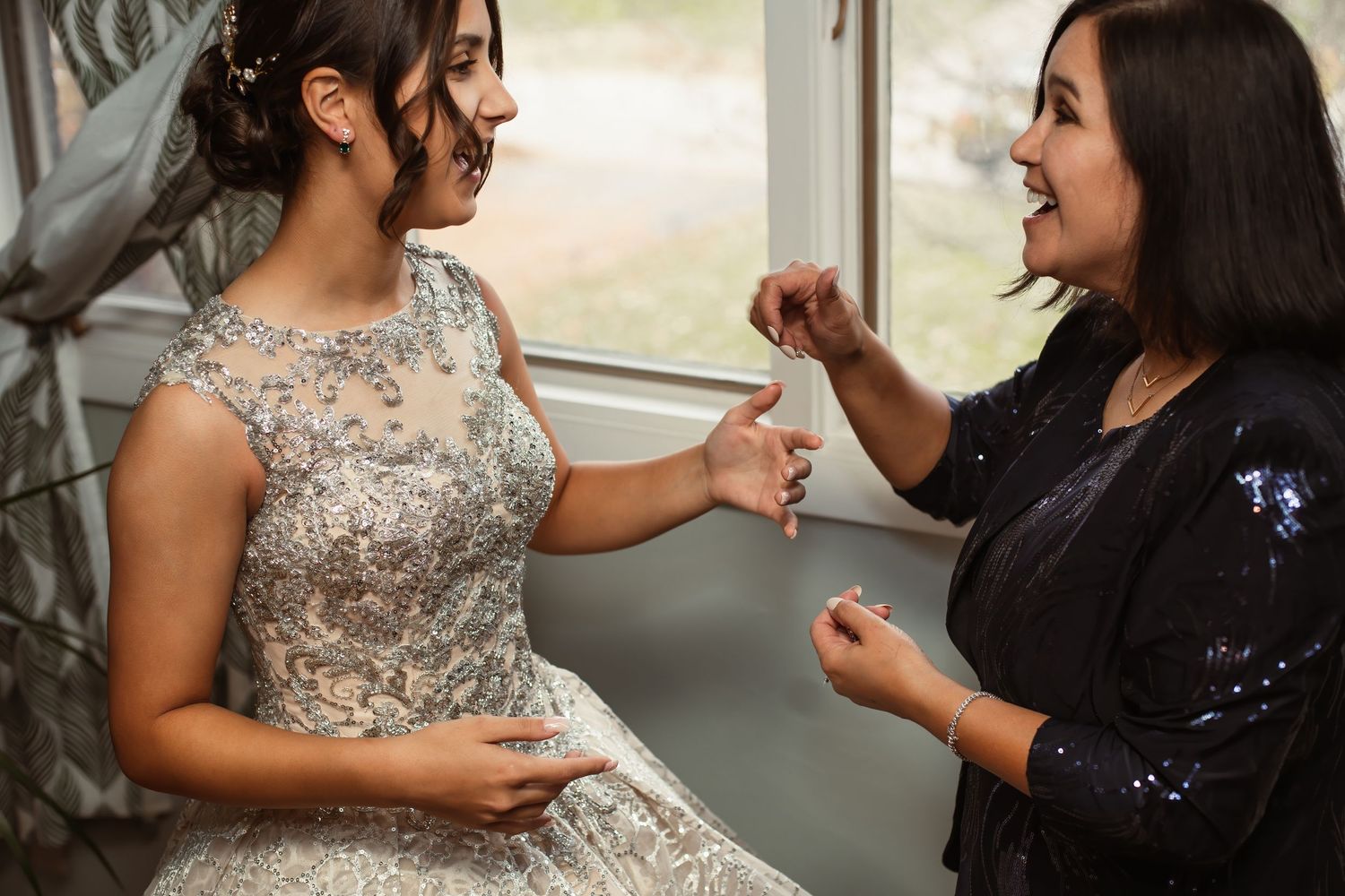 Two people share a joyful moment during wedding preparations.