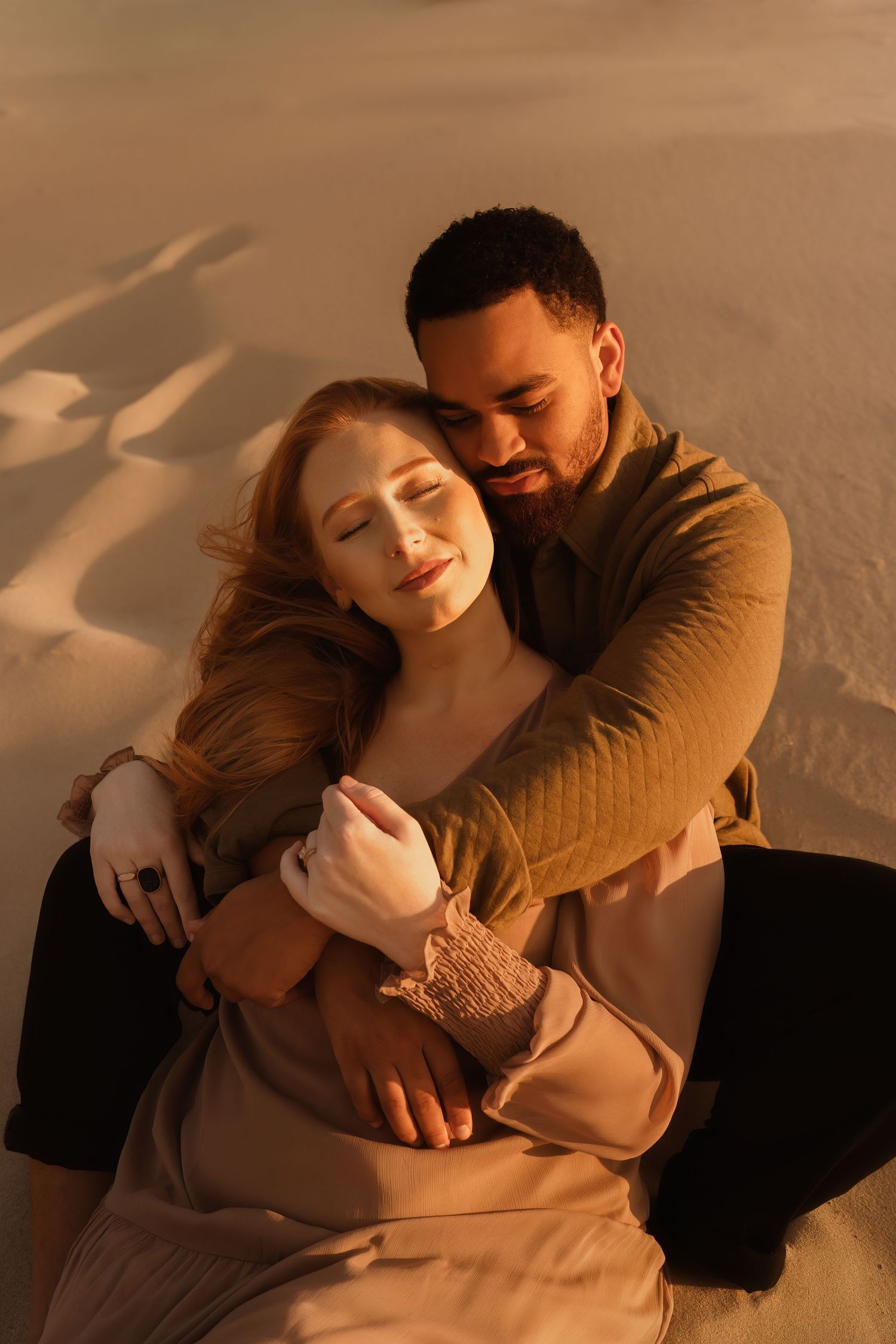 Couple sharing a tender moment on the beach during golden hour.