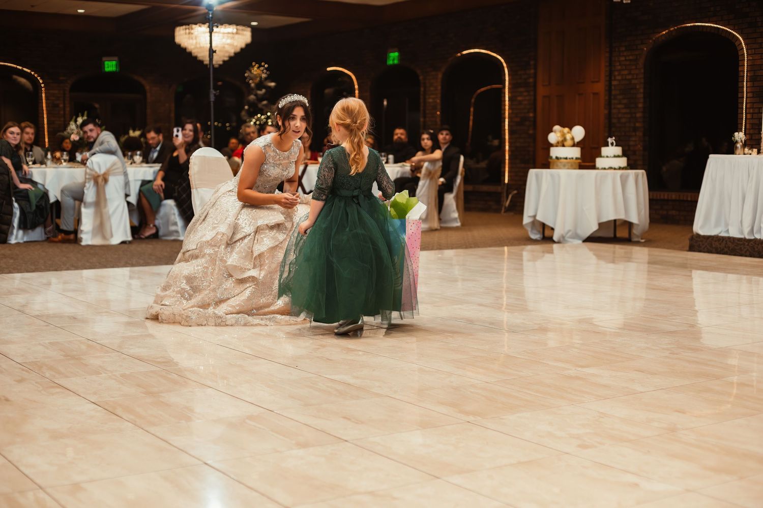 Three people dancing together on a ballroom floor during a formal celebration.