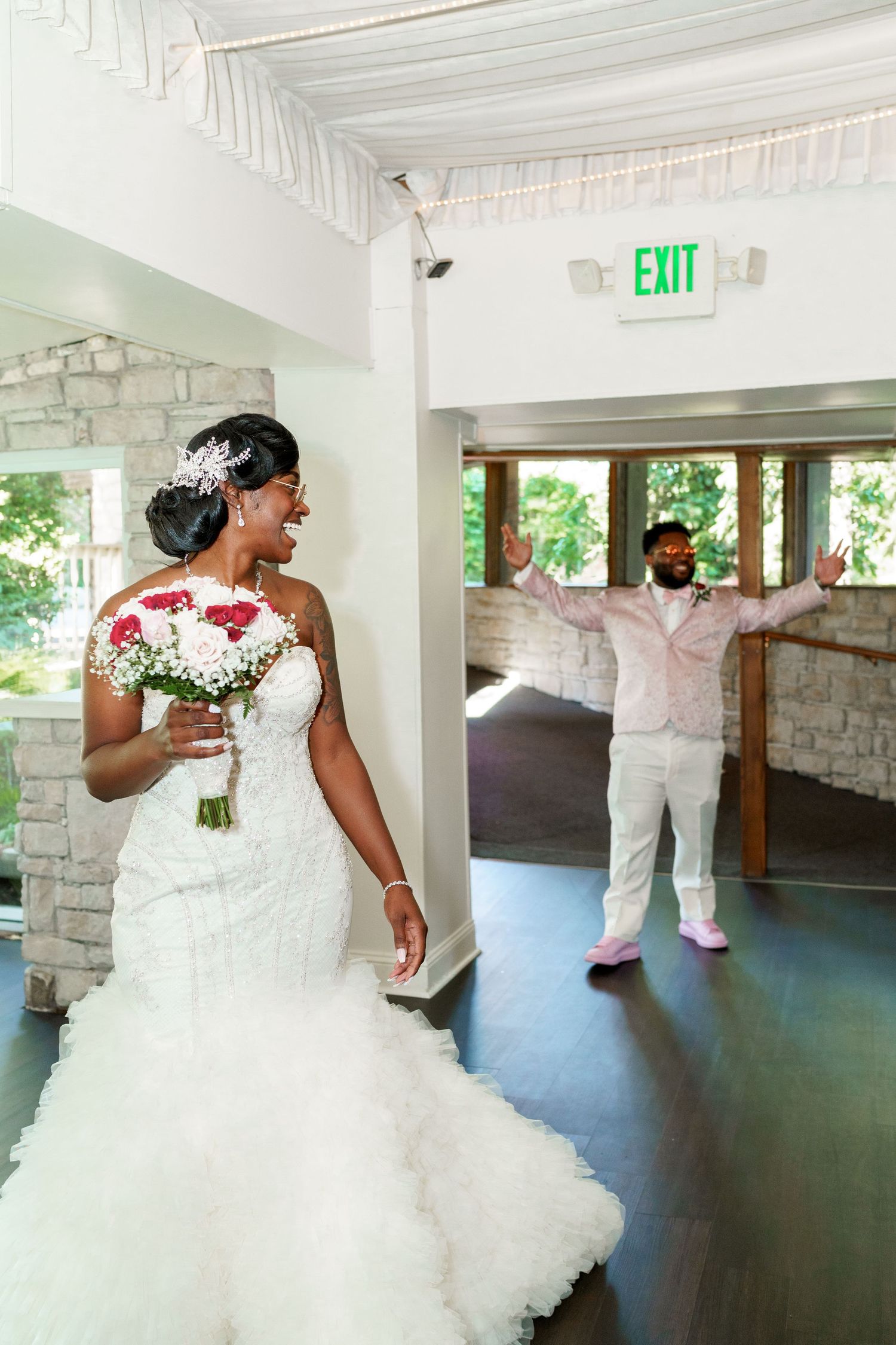 A joyful wedding celebration unfolds in a light-filled venue with stone accents.