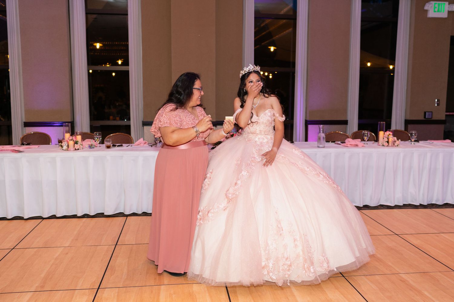 Dance floor scene in a reception hall with purple ambient lighting and white event decorations.