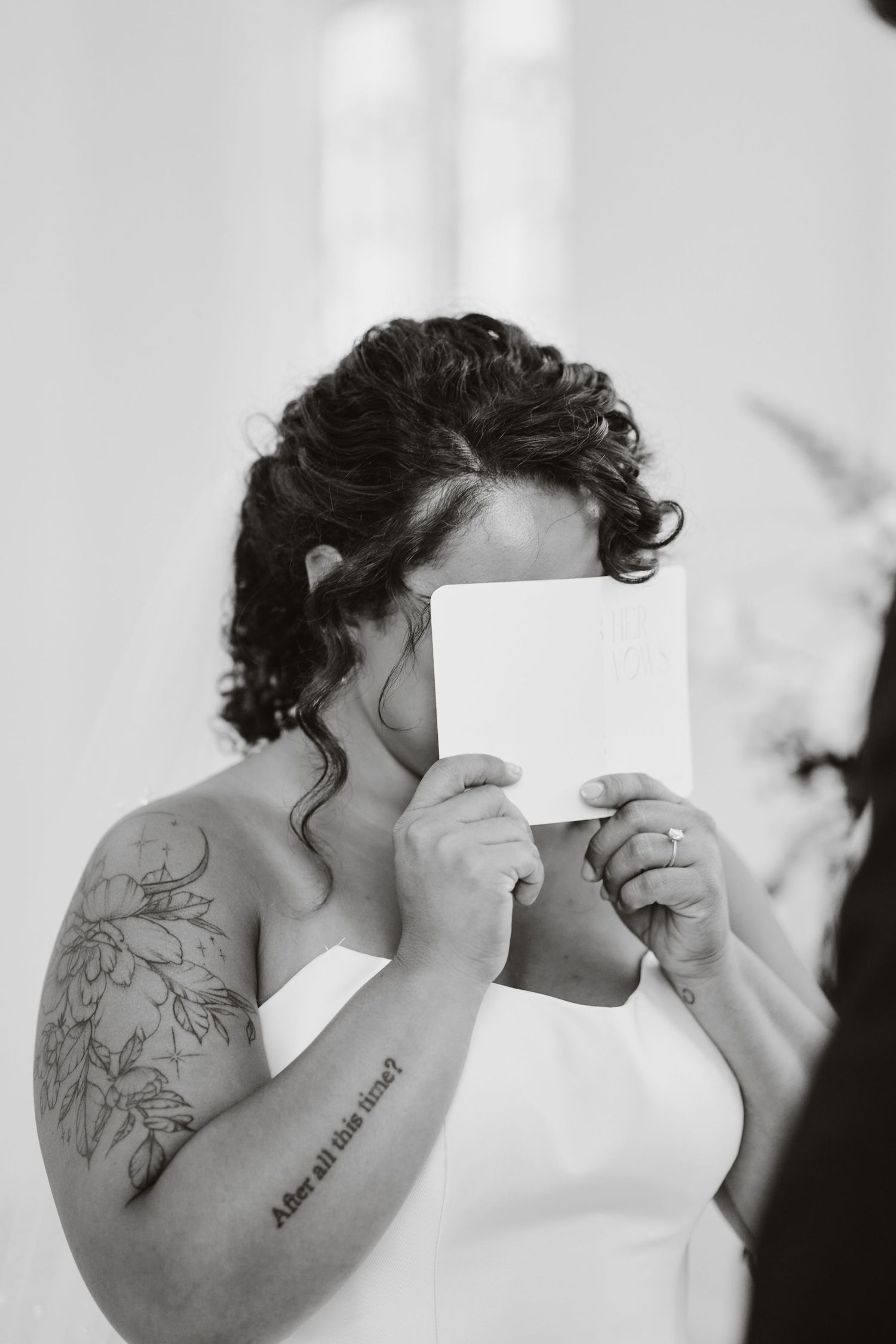 Black and white portrait of person holding letter during wedding ceremony.