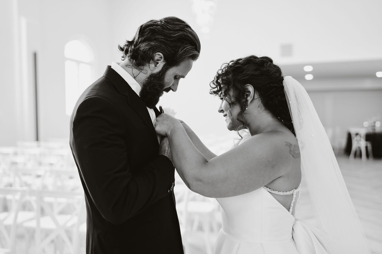 Black and white photo of a romantic dancing moment in an elegant wedding venue.