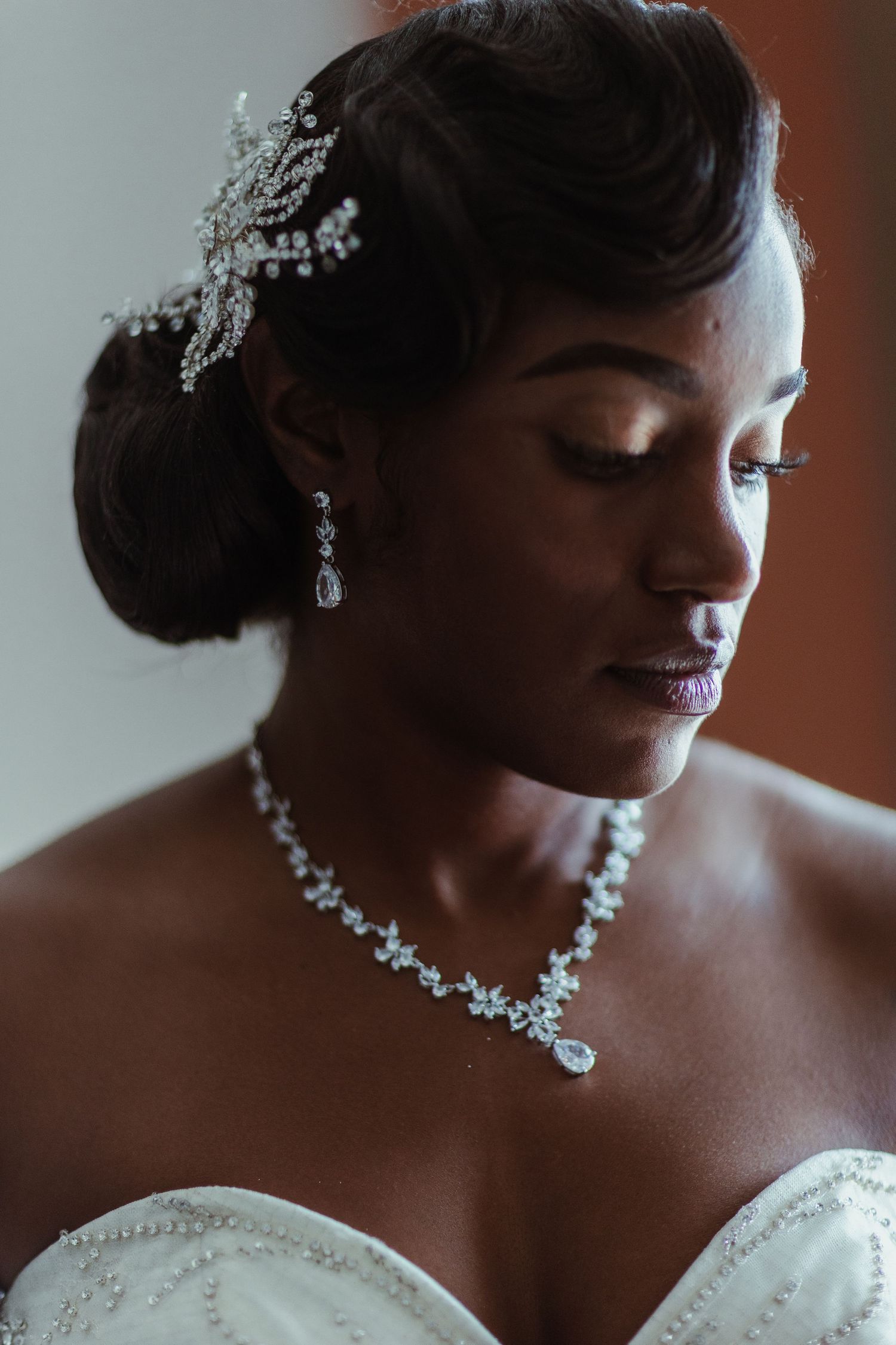 Elegant bridal portrait featuring sparkling crystal jewelry and a classic updo hairstyle with delicate hair accessories.