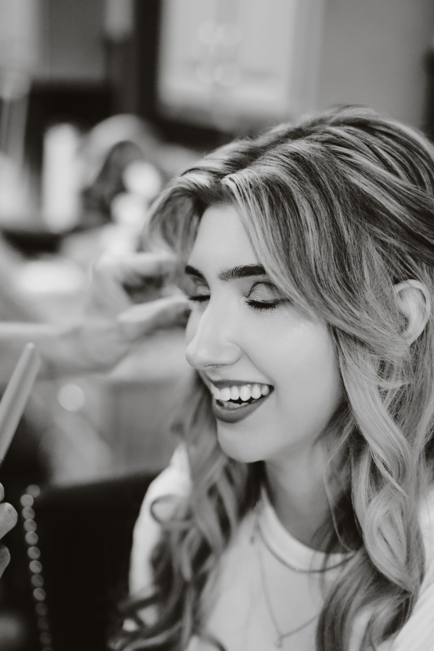 A series of black and white candid shots showing genuine laughter and joyful expressions in a natural setting.