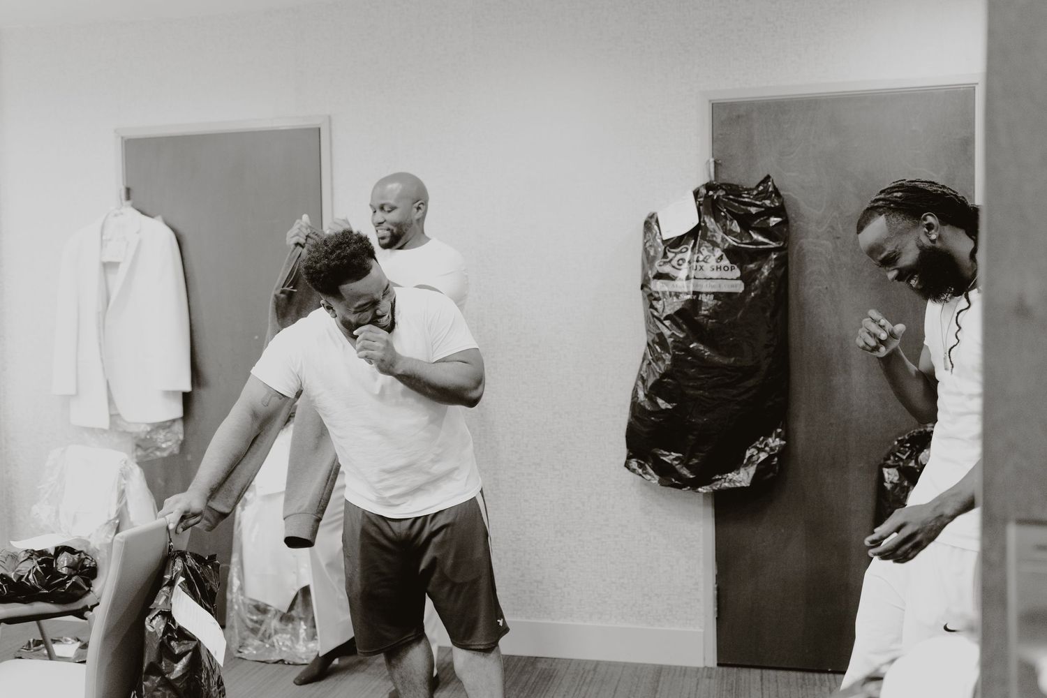 Black and white photo of people hanging out in casual room setting.