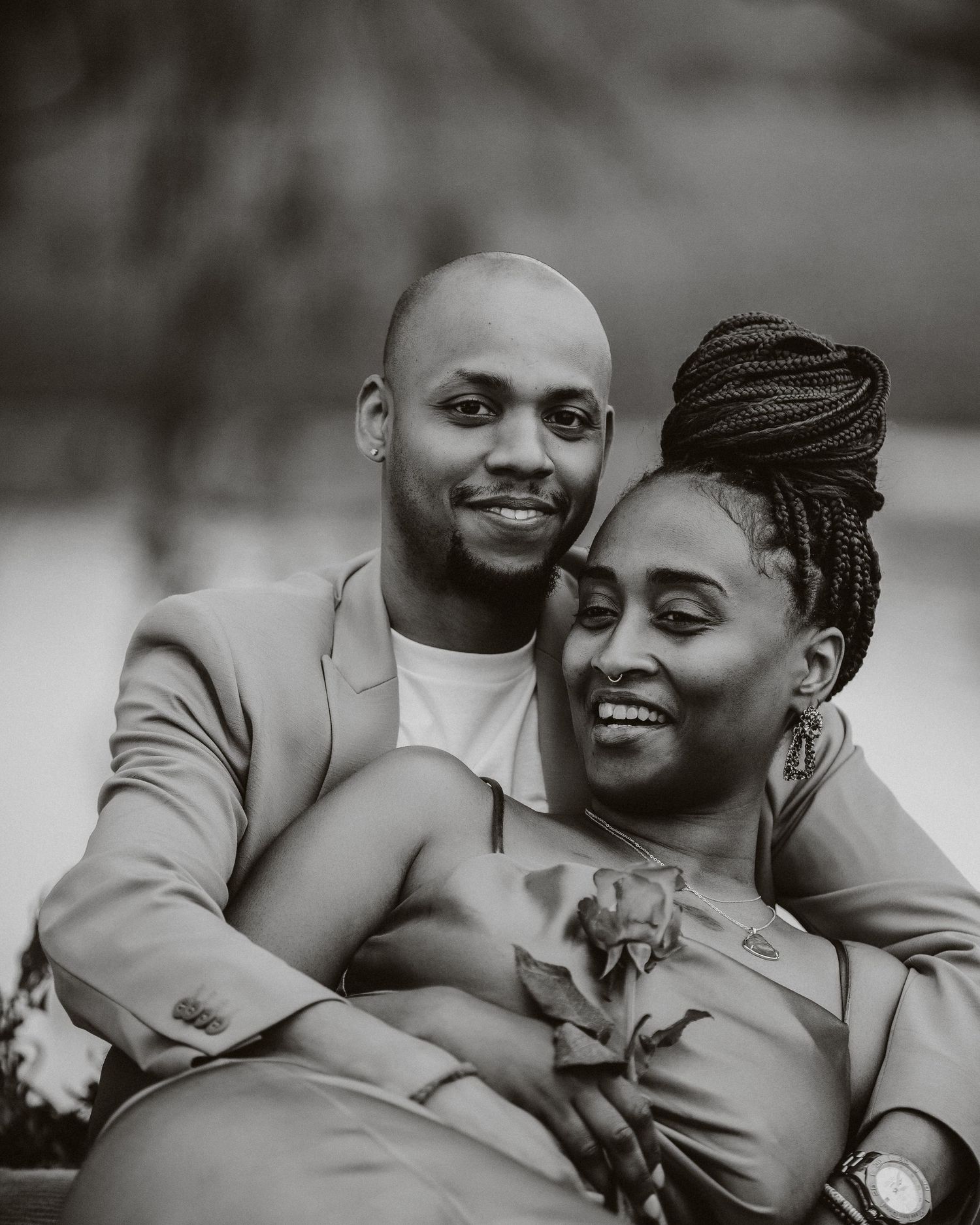 Intimate black and white portrait of a couple embracing outdoors.
