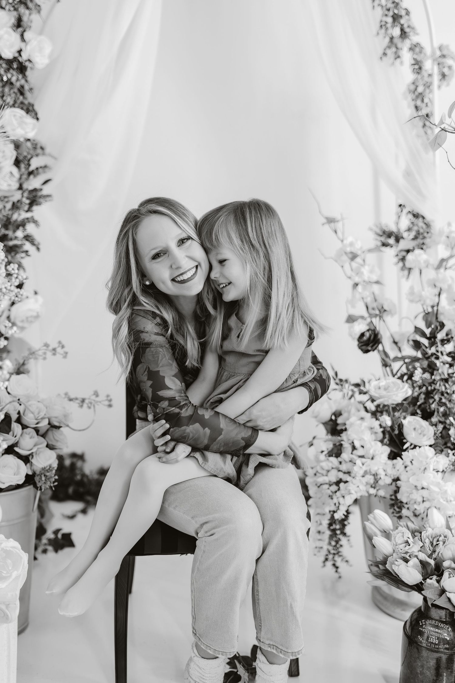 A couple shares joyful moments together in black and white photos against a light backdrop with floral elements.