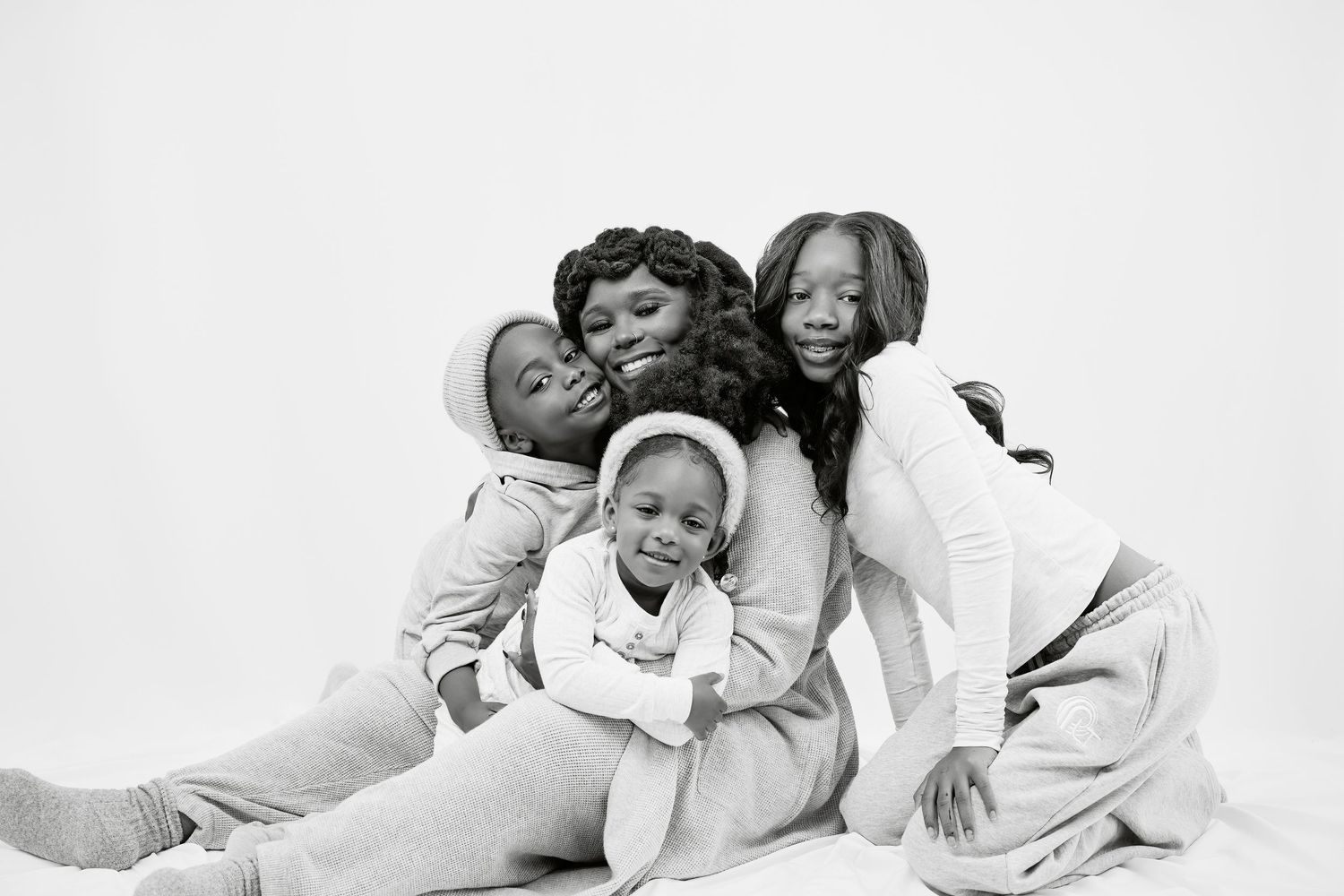A series of black and white photos showing joyful people laughing and having fun while lying down together.