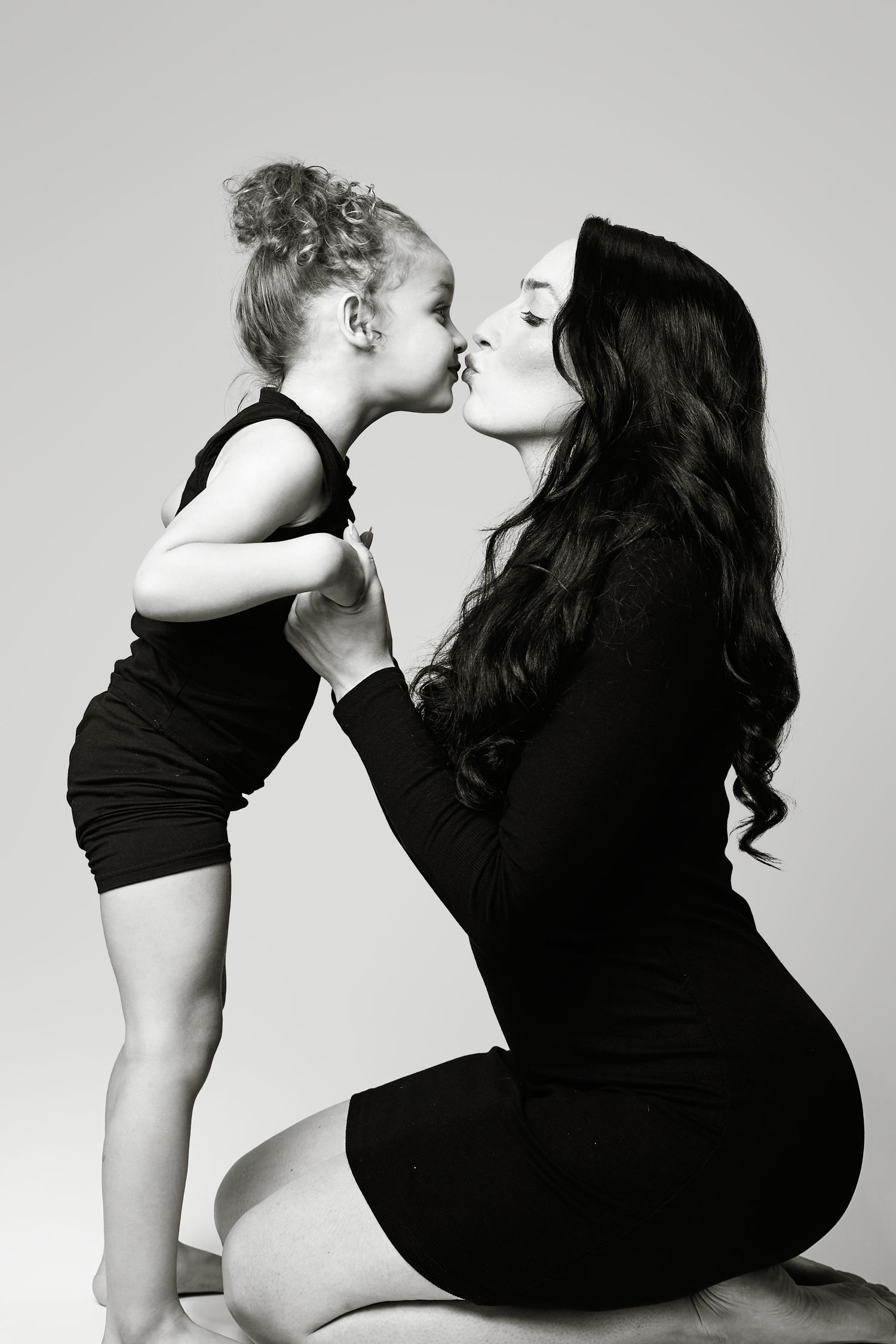 Black and white artistic photo series showing tender embrace between parent and child in silhouette style.