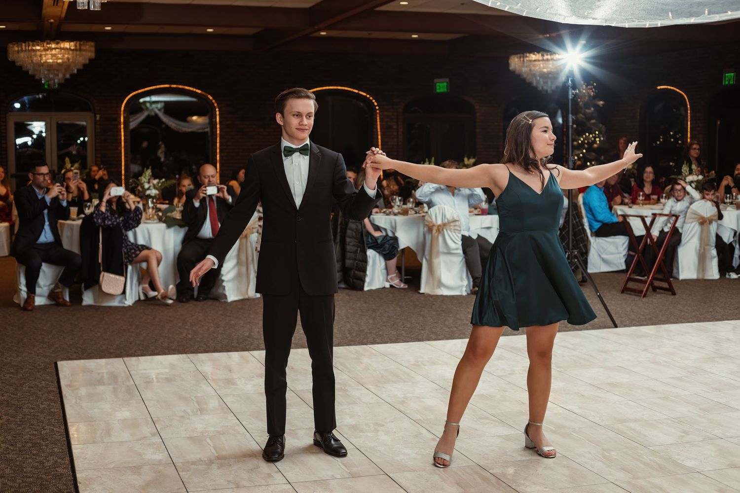 Wedding guests perform a choreographed dance routine on the reception dance floor.