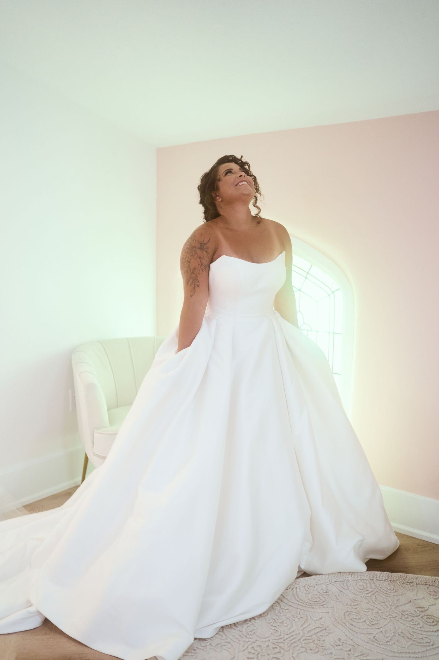 A flowing white wedding dress with full skirt captured in soft natural light.
