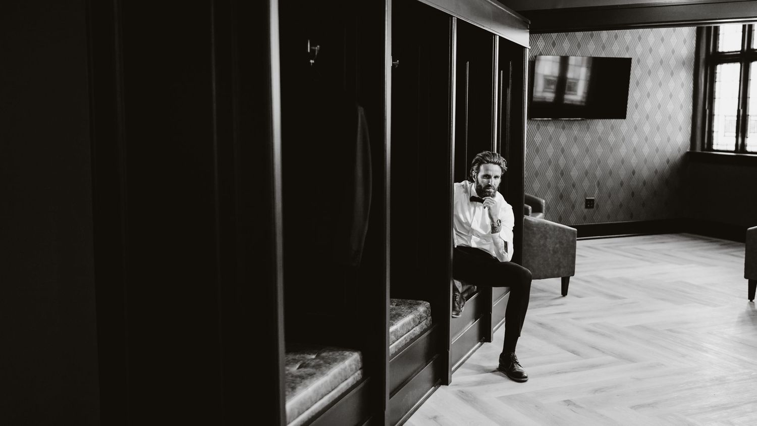 Black and white photo of a vintage interior with wooden floors and closet doors.