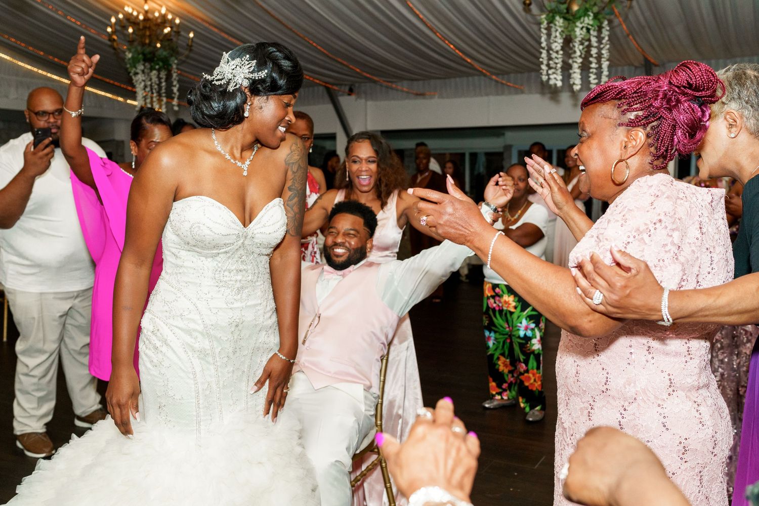 Wedding reception scene with energetic dancing and celebration in a decorated venue.