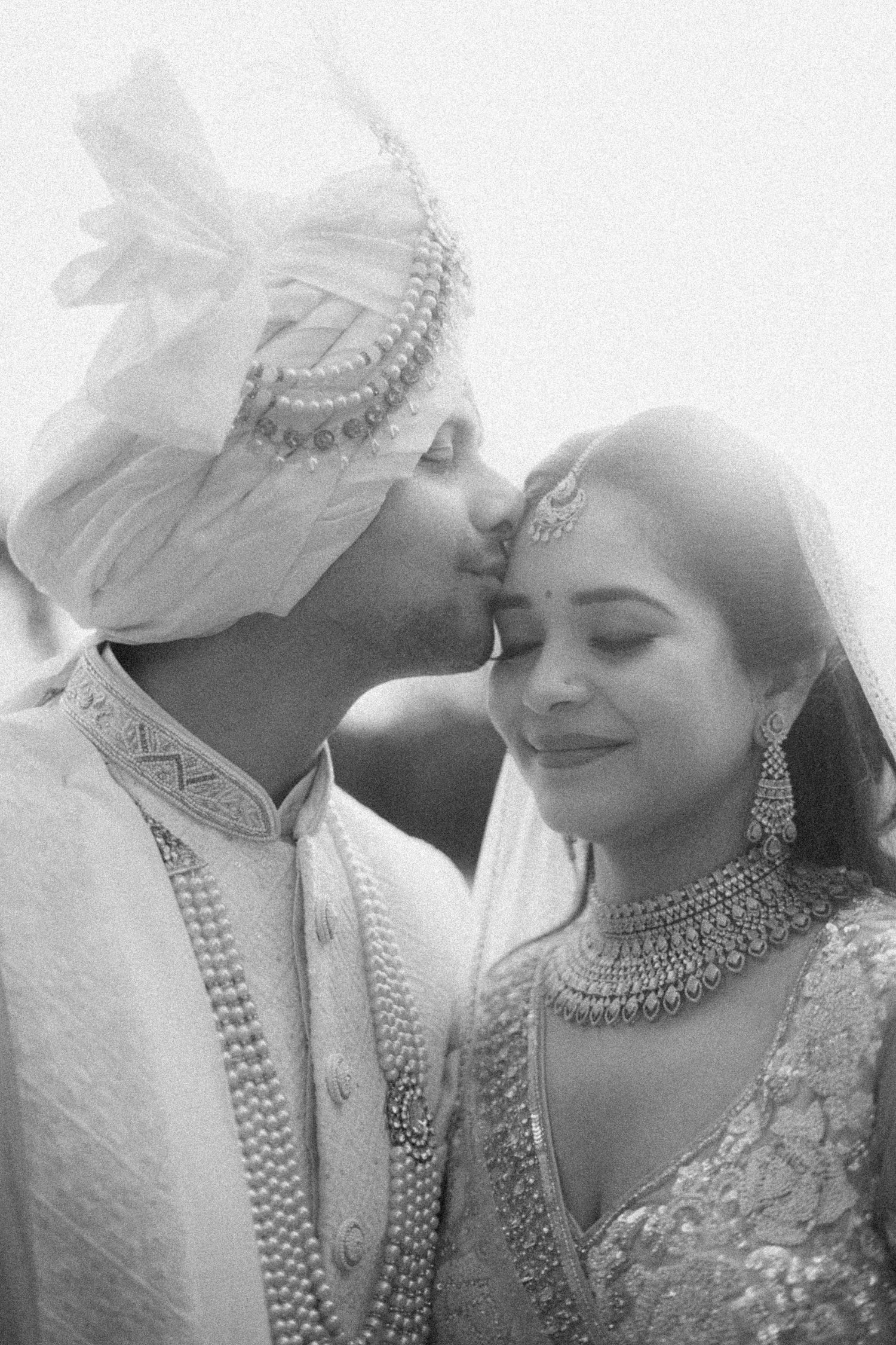 Black and white romantic portraits capturing intimate moments in traditional wedding attire.