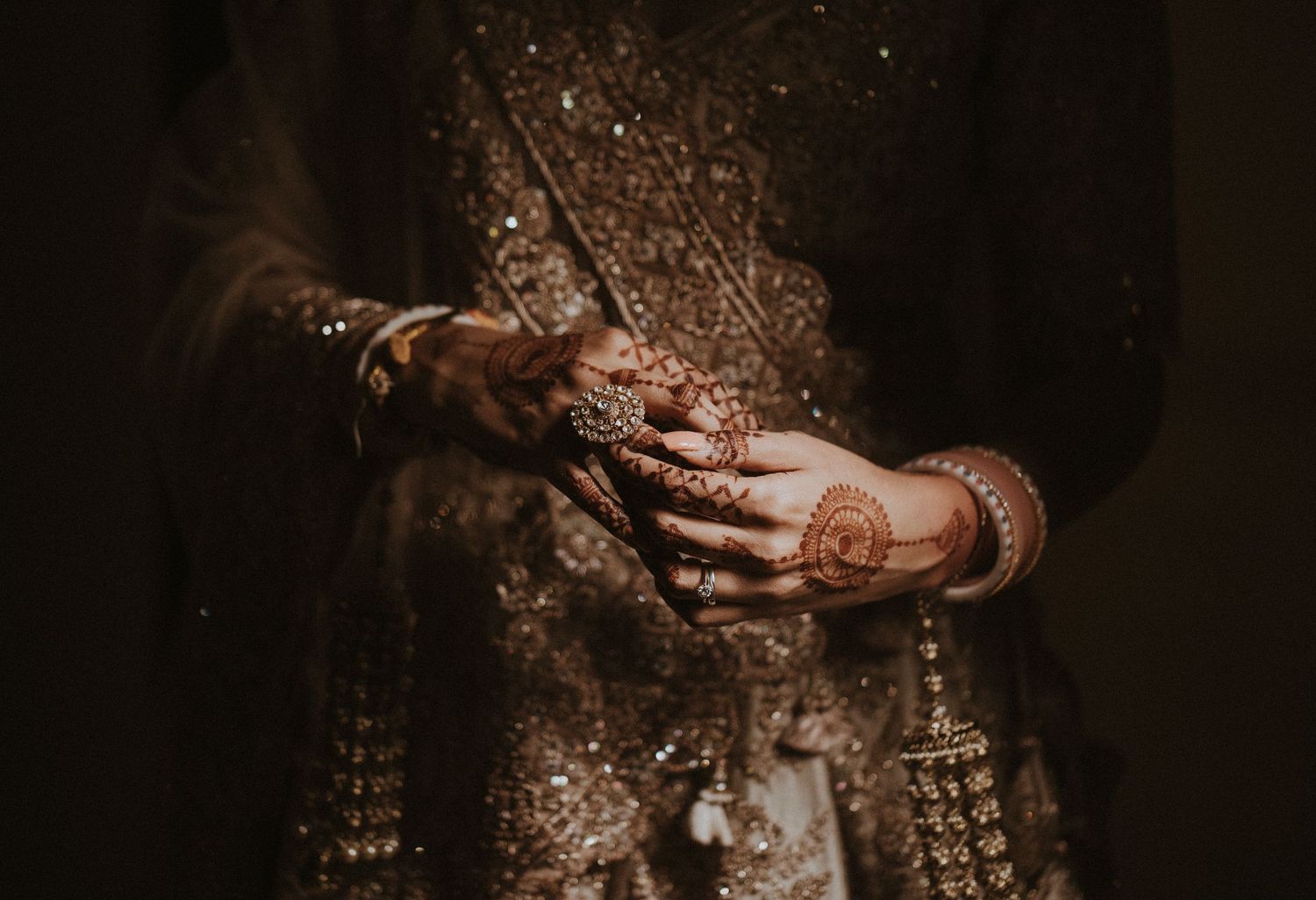 A dark and moody series of wedding photos showing intimate moments between a couple in golden light and shadows.