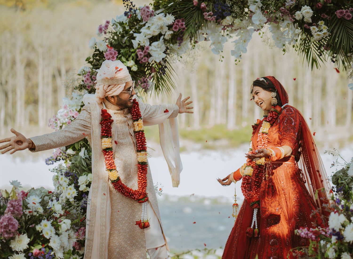 Wedding ceremony with orange and red decor elements and floral arrangements.