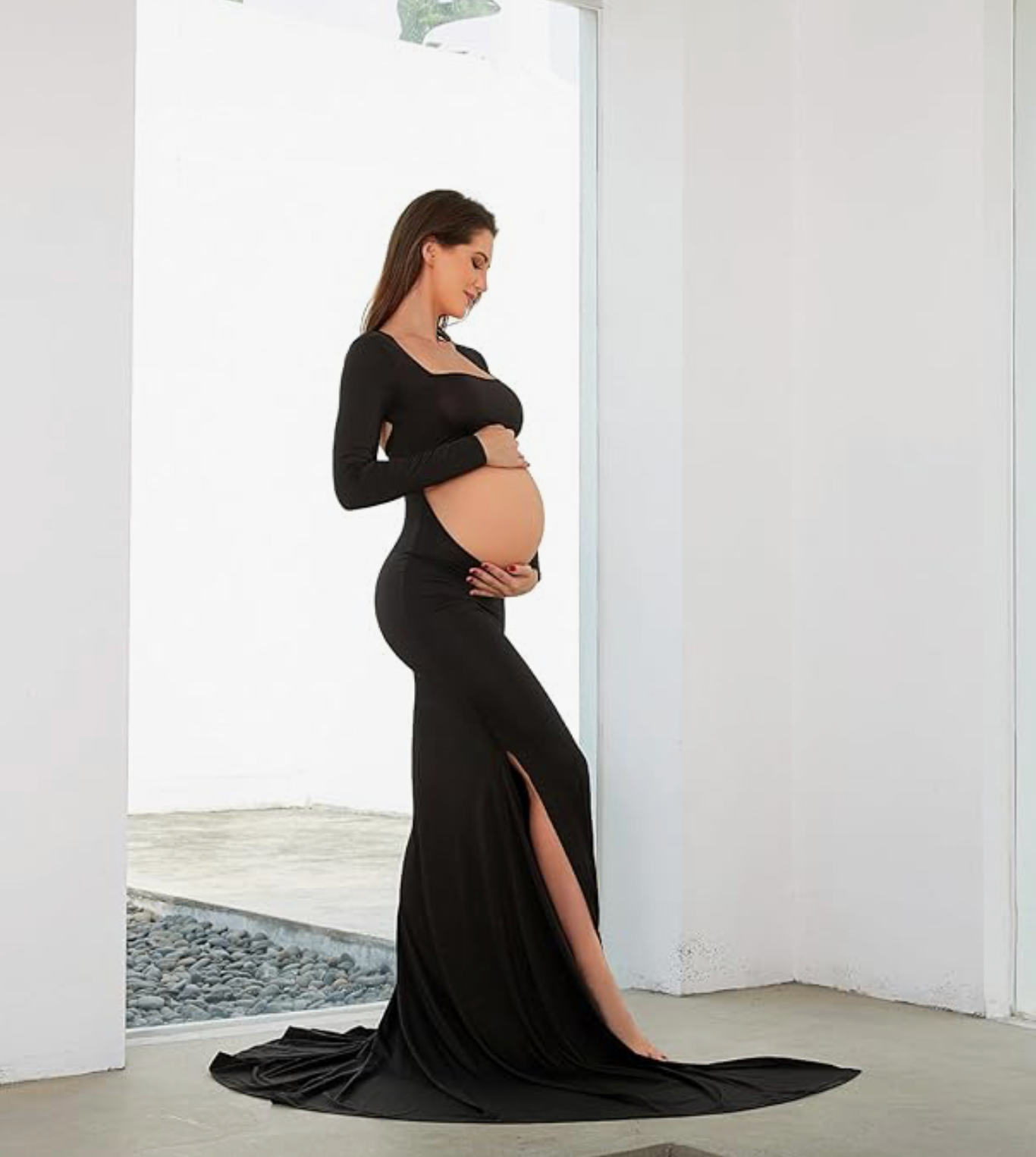 Elegant maternity photoshoot series in black dress against white walls showing pregnancy silhouette and curves.