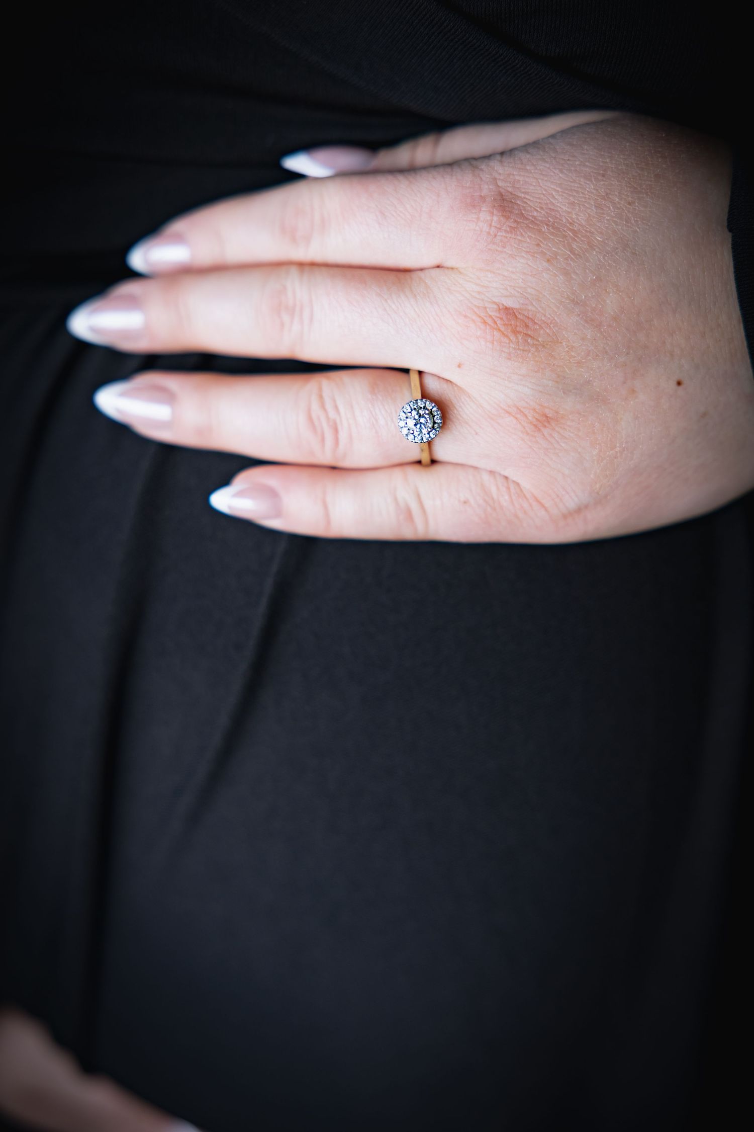 Close-up series of a hand displaying an engagement ring against a black background.