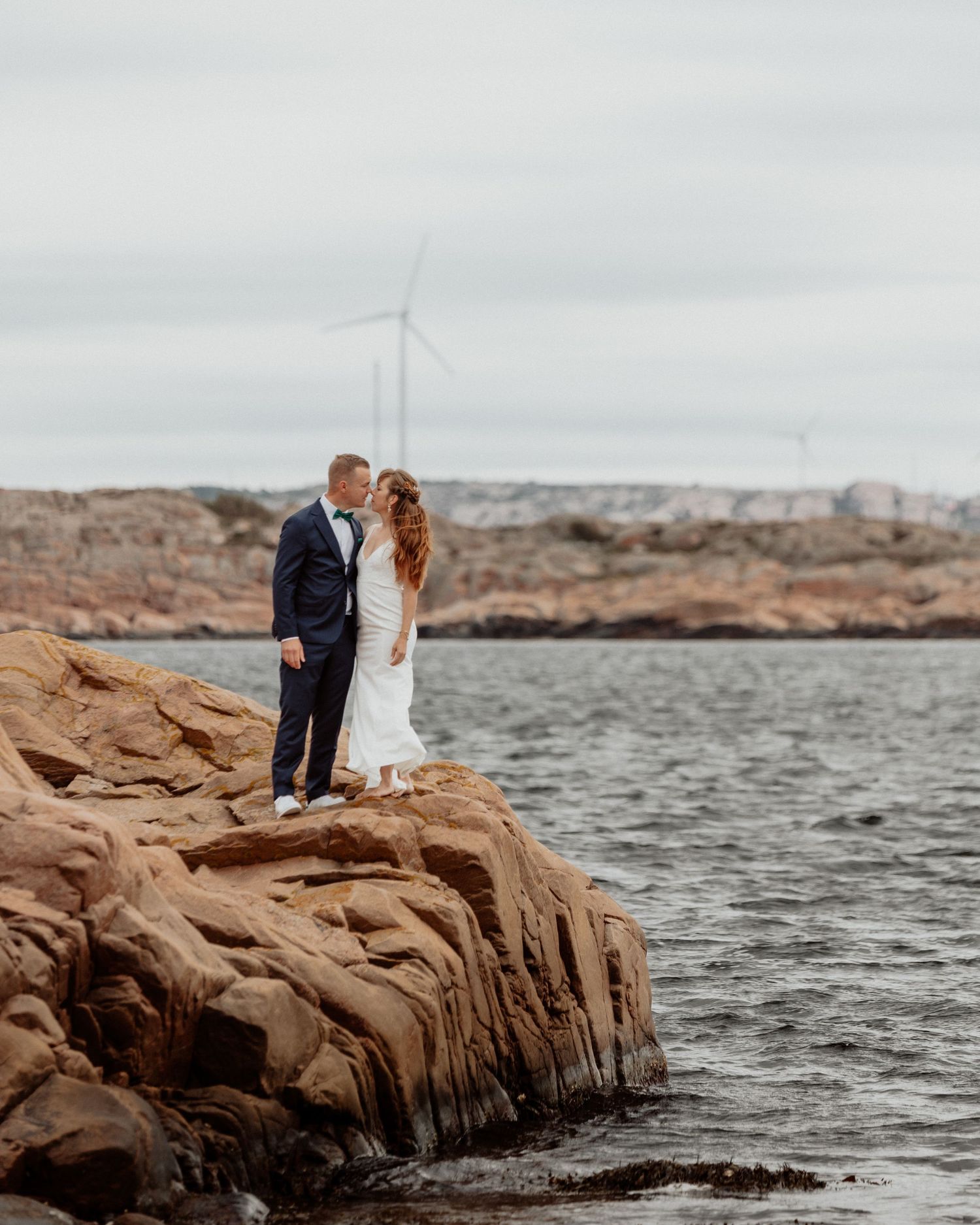 Brudpar stående på en klippa vid havet på bohus-malmön i bohuslän