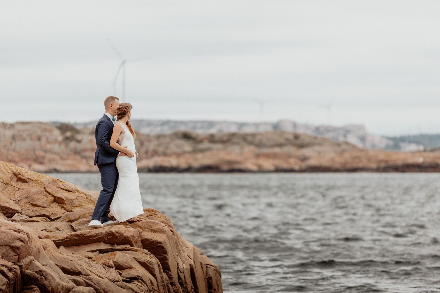 Brudpar stående på en klippa vid havet på bohus-malmön i bohuslän