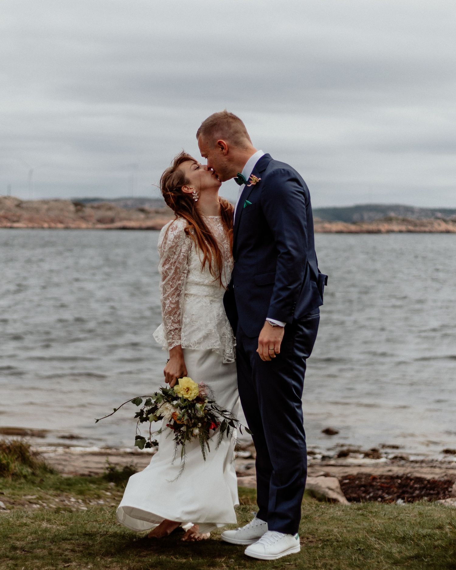 Vackert porträtt av bröllopsbar på en strand på Bohus-malmön precis vid havet och klippor.