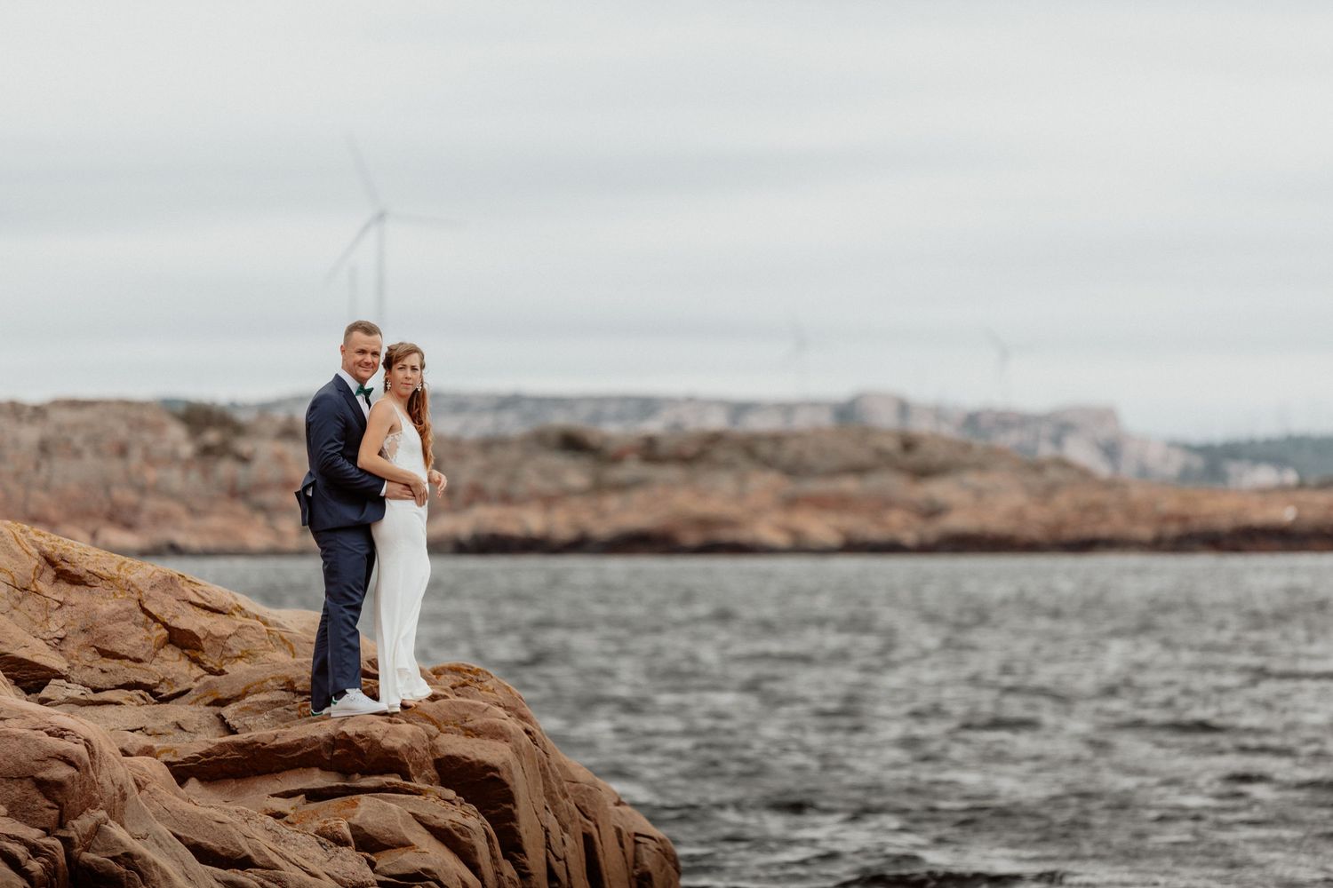 Brudpar stående på en klippa vid havet på bohus-malmön i bohuslän
