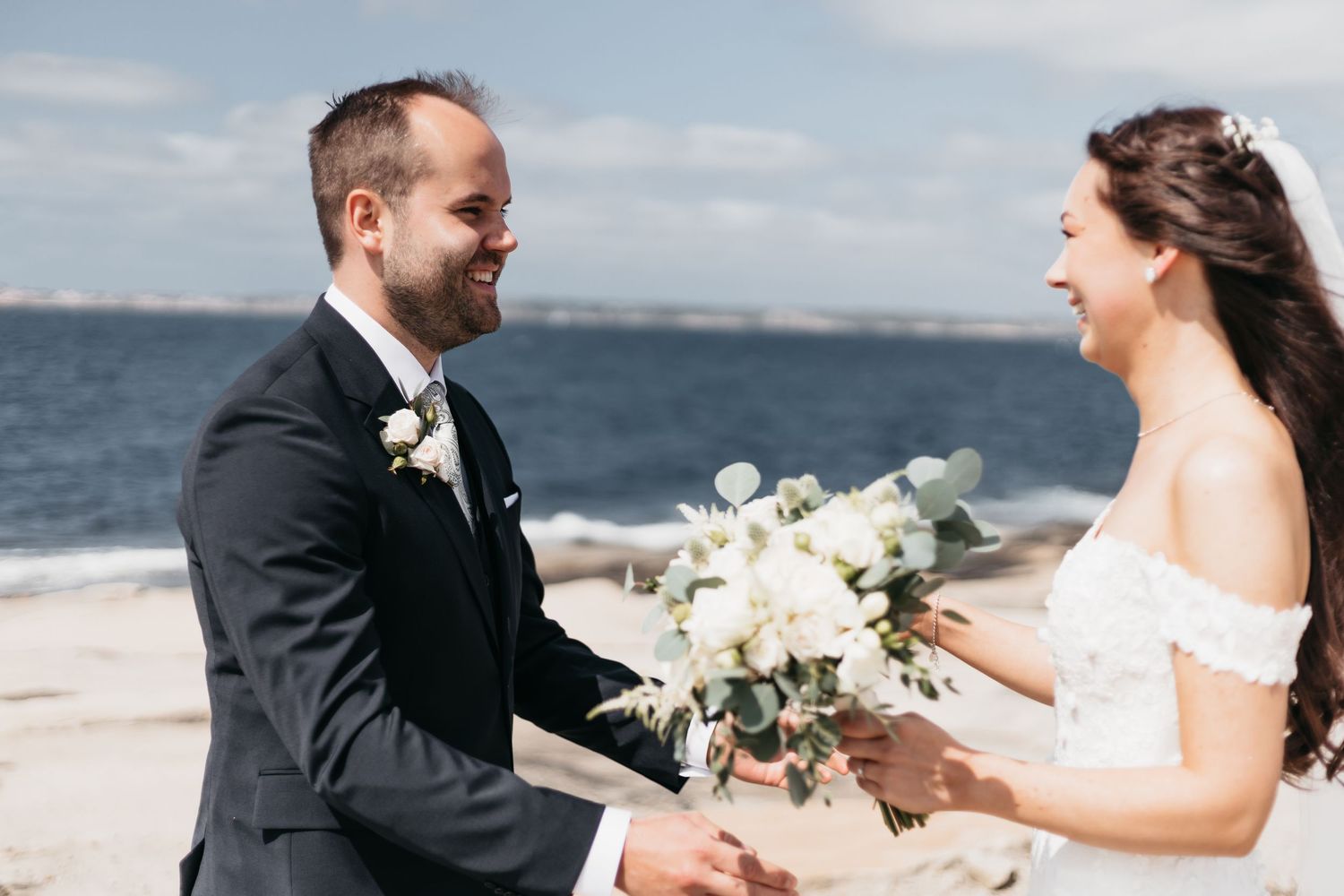 Brud och brudgum ser varandra i klänning och kostym för första gången, på bohus-malmön vid havet
