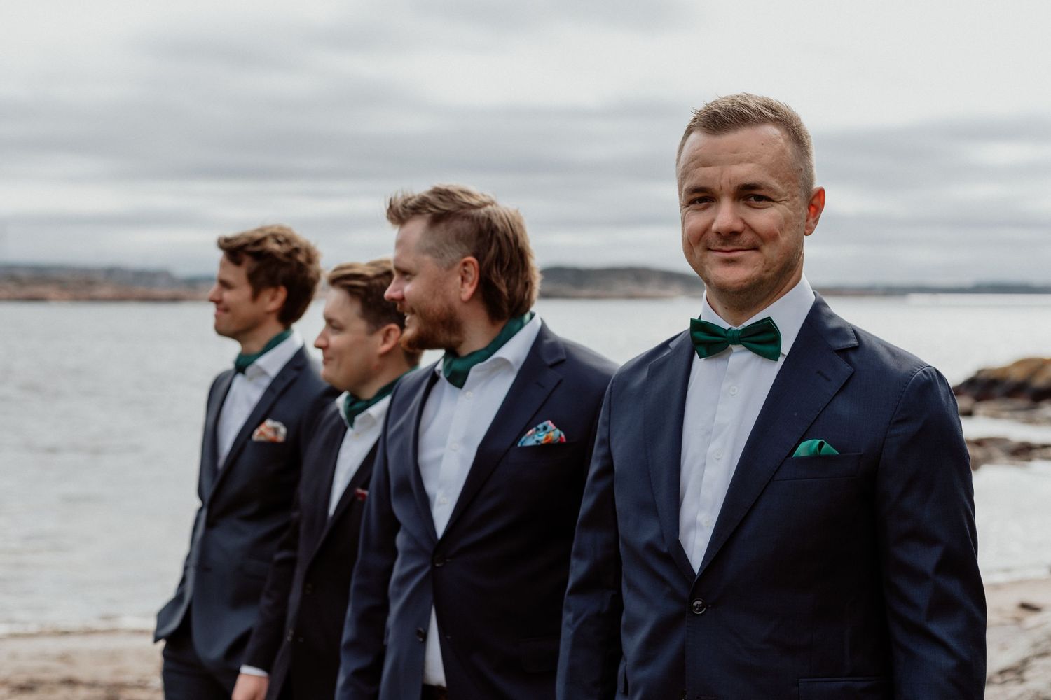 Brudgum och marskalker med havet som bakgrund