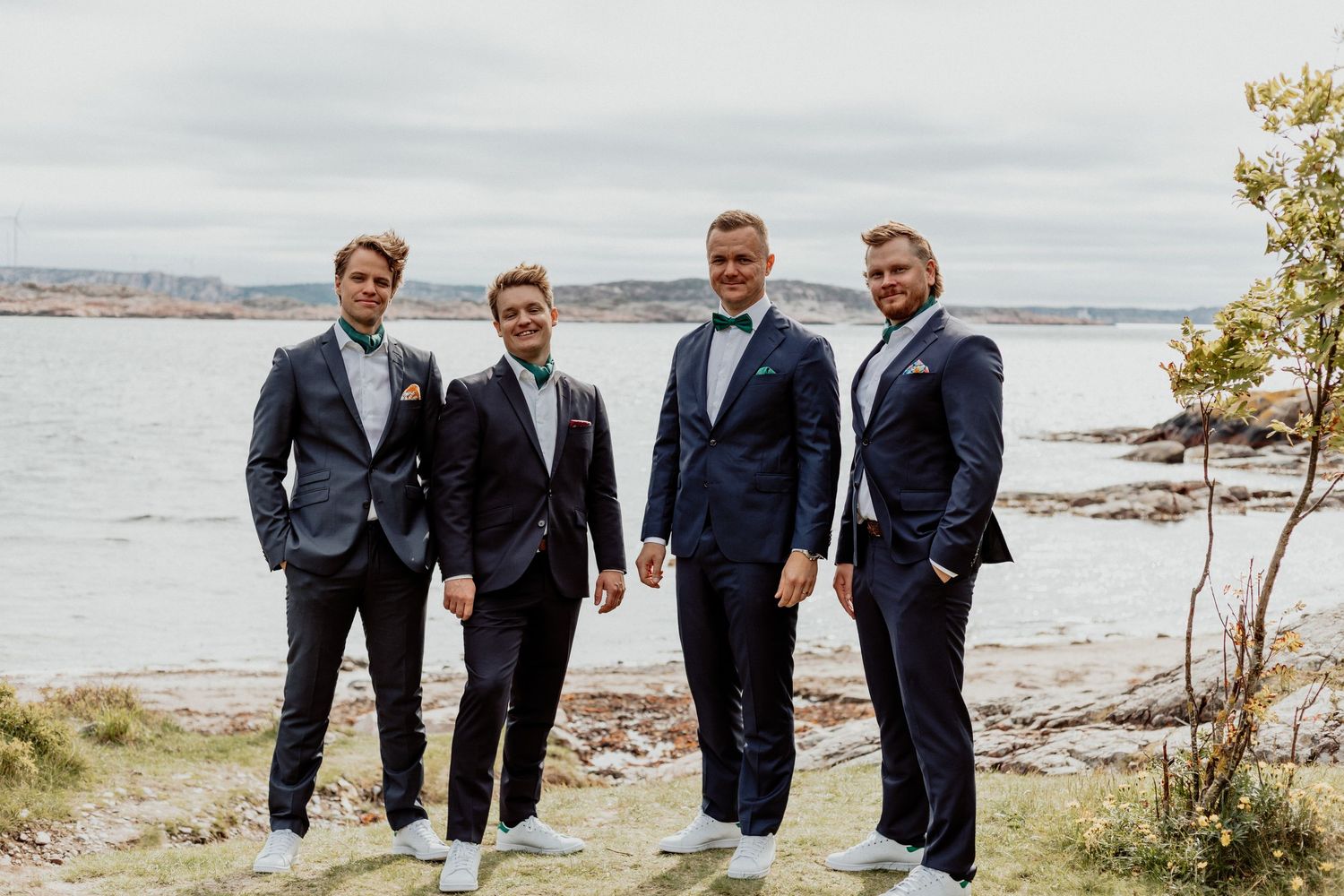 Brudgum och marskalker med havet som bakgrund