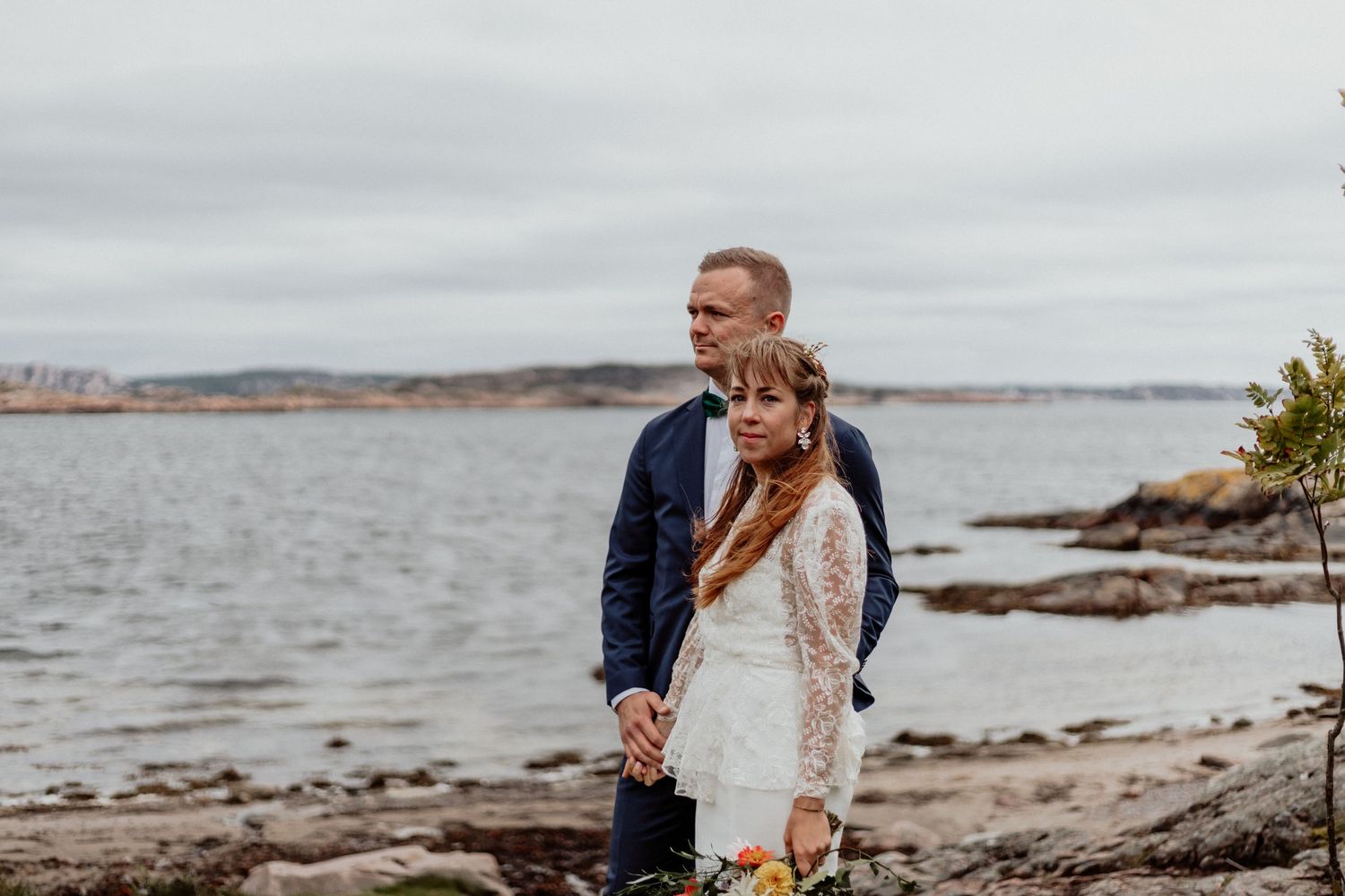 Vackert porträtt av bröllopsbar på en strand på Bohus-malmön precis vid havet och klippor.