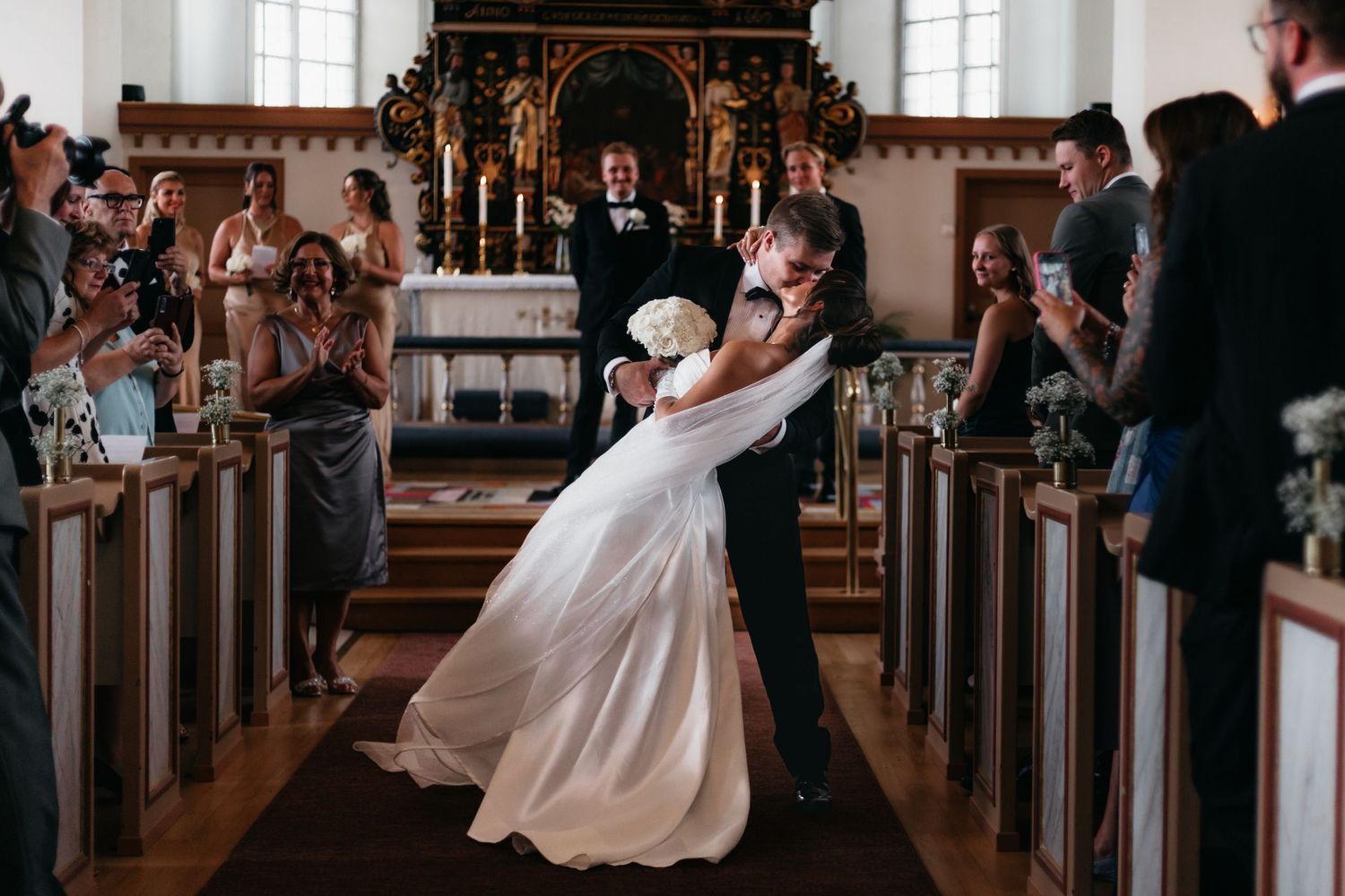 Vackert brudpar som kysser varandra i kyrkan efter vigsel i Lysekil, bohuslän.