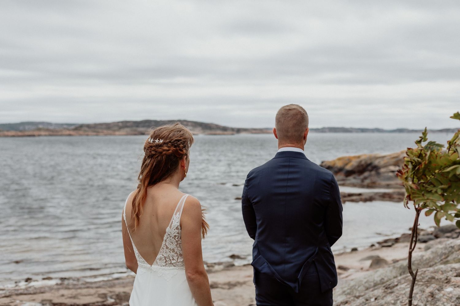 Brudpar som njuter av varandra sällskap vid hav och klippor på bohus-malmön i bohuslän