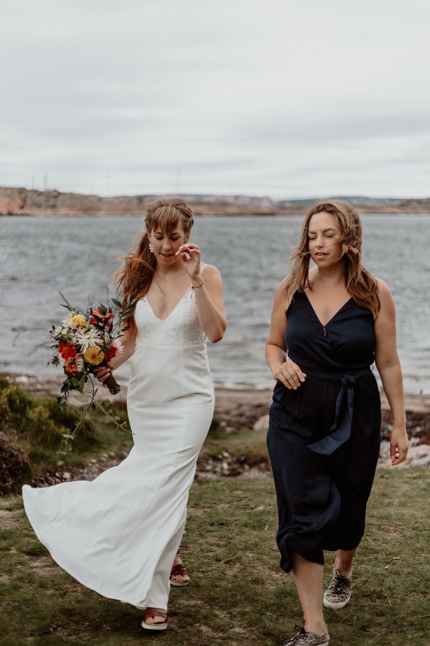 Brud och brudtärna med havet som bakgrund